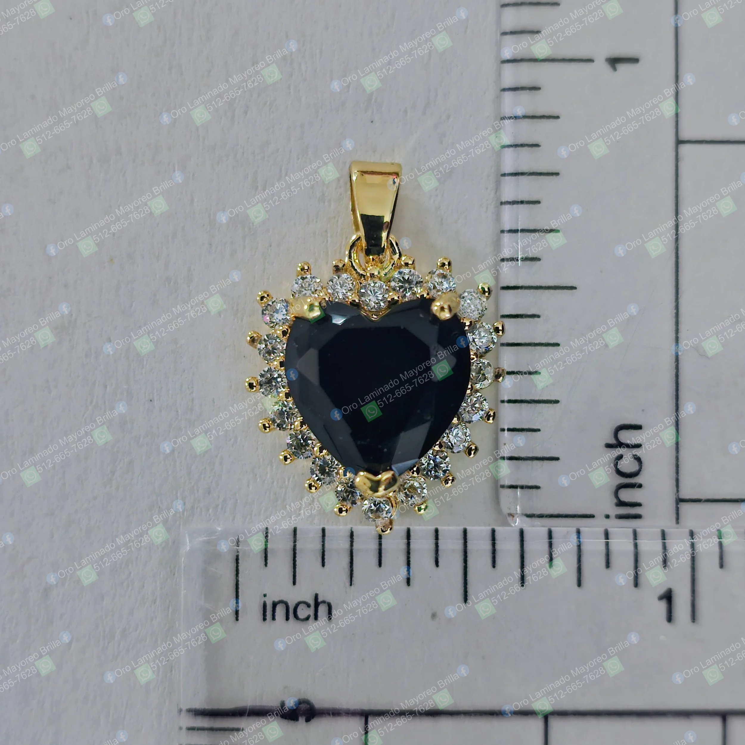 Dije de corazon color oro con piedra azul oscuro y piedras decorativas visibles | Gold color heart pendant with dark blue stone and visible decorative stones