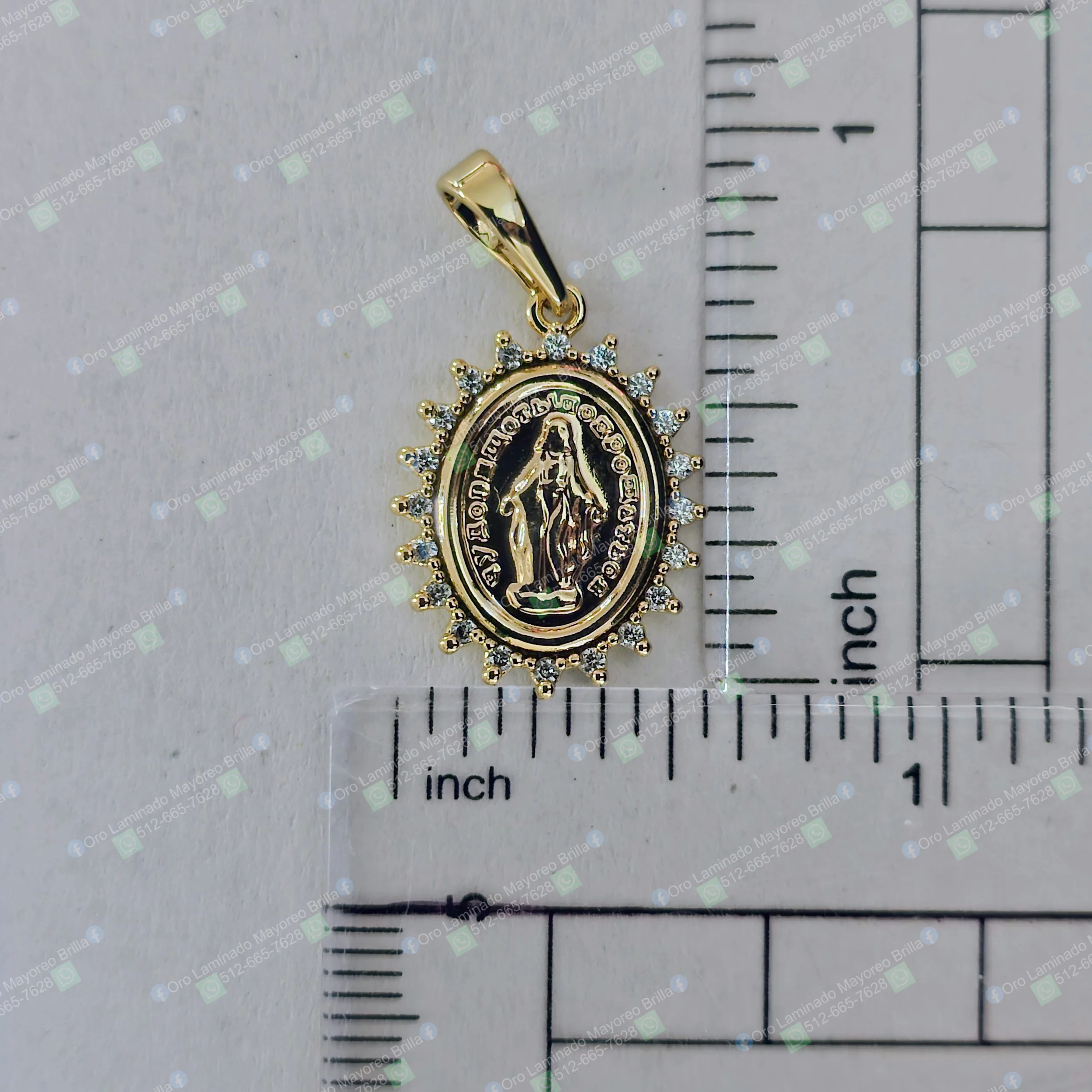 Dije Virgen ovalado color oro con piedras decorativas visibles y figura religiosa central | Oval shaped gold color Virgin pendant with visible decorative stones and central religious figure