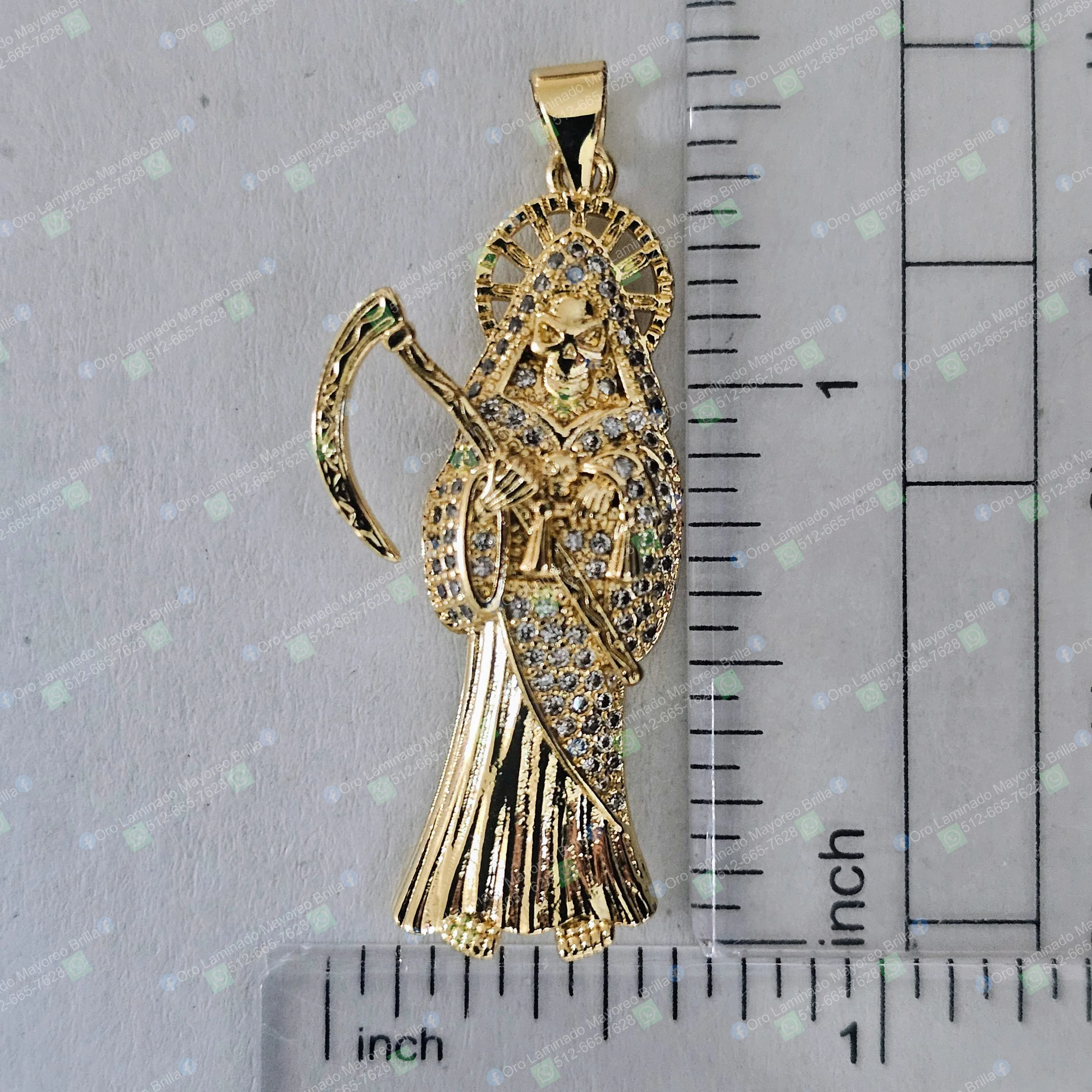 Dije religioso Santa Muerte color oro con piedras decorativas visibles | Gold color Santa Muerte religious pendant with visible decorative stones