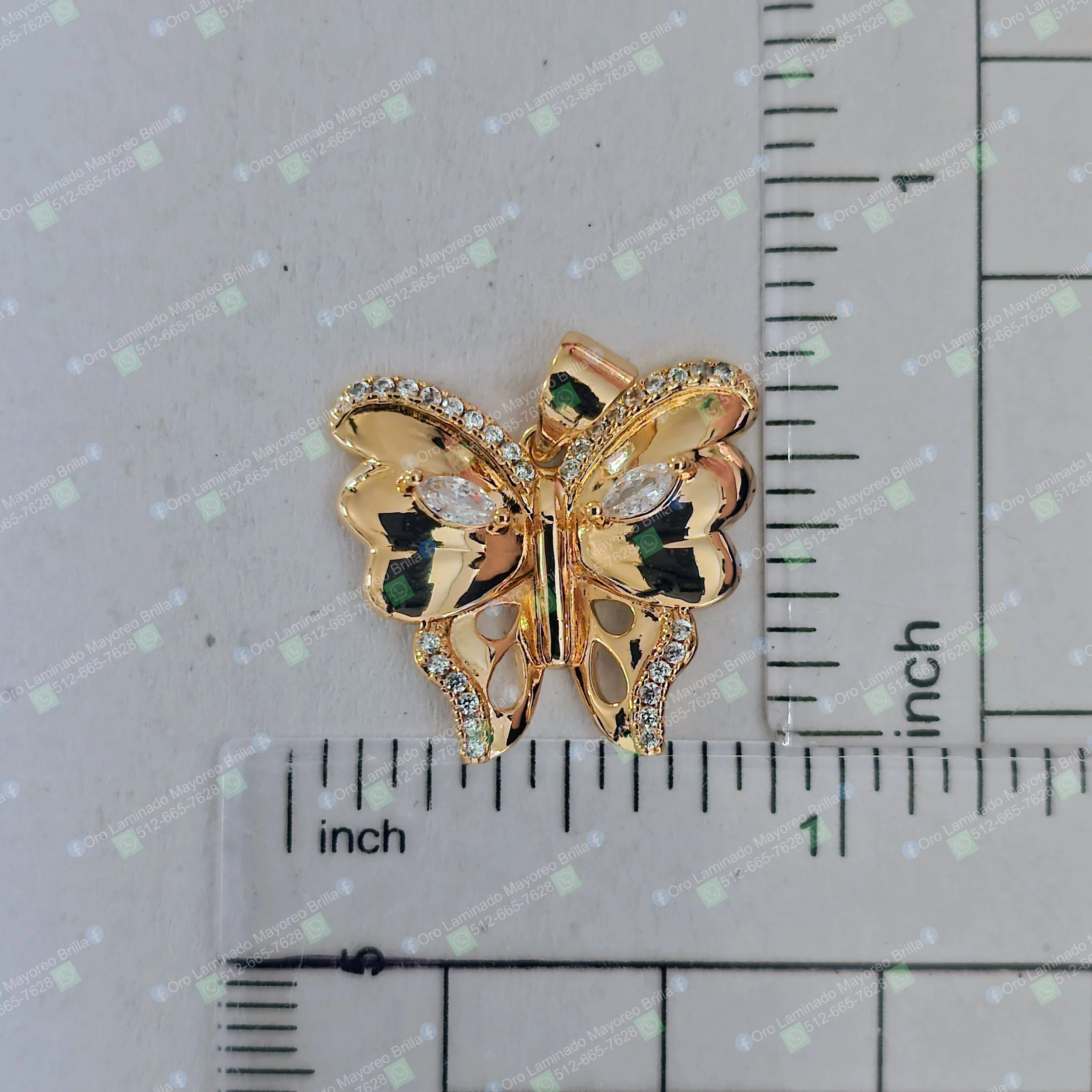 Dije de mariposa color oro con piedras decorativas visibles | Gold color butterfly pendant with visible decorative stones