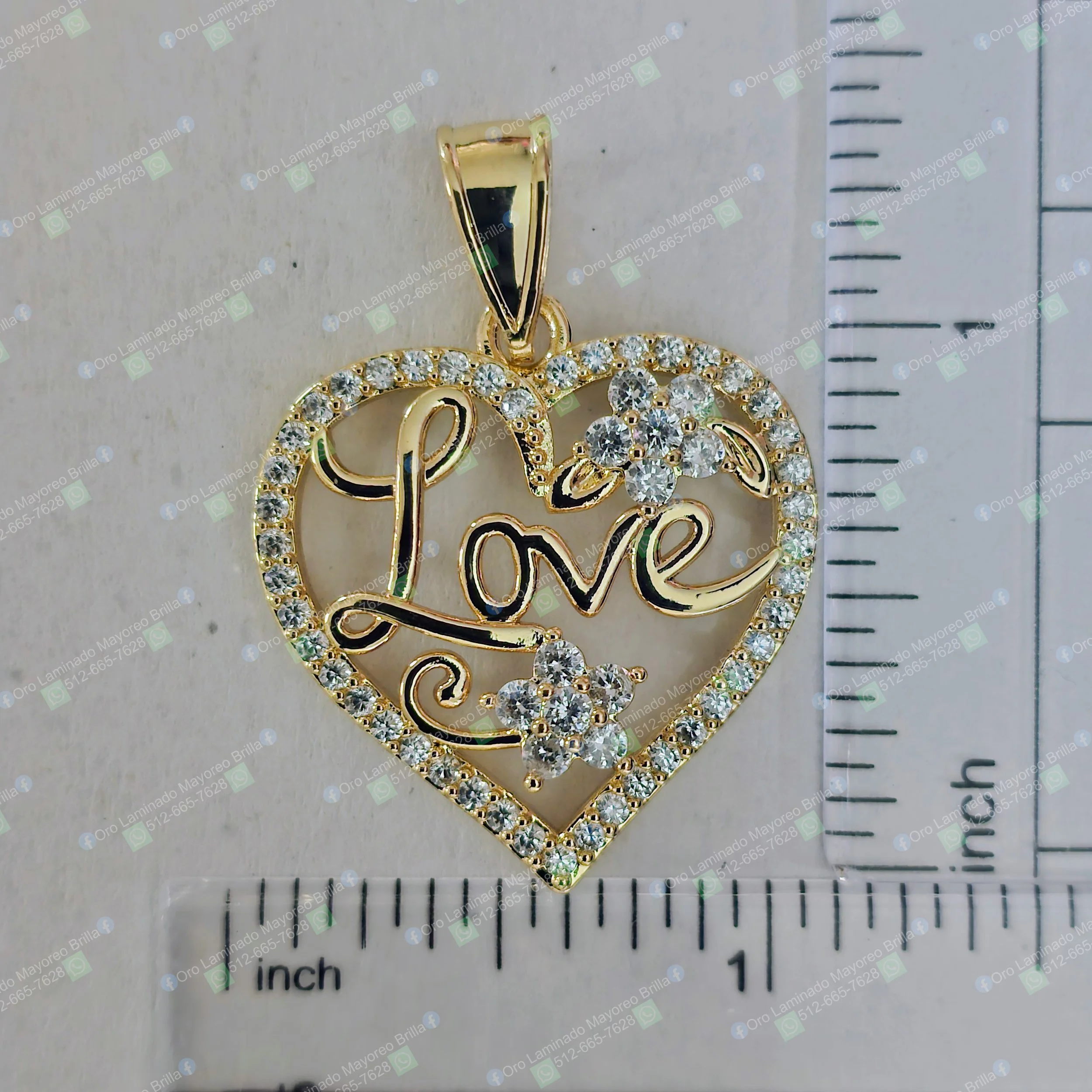 Dije de corazon color oro con texto "Love" y flores con piedras decorativas visibles | Gold color heart pendant with "Love" text and flowers with visible decorative stones