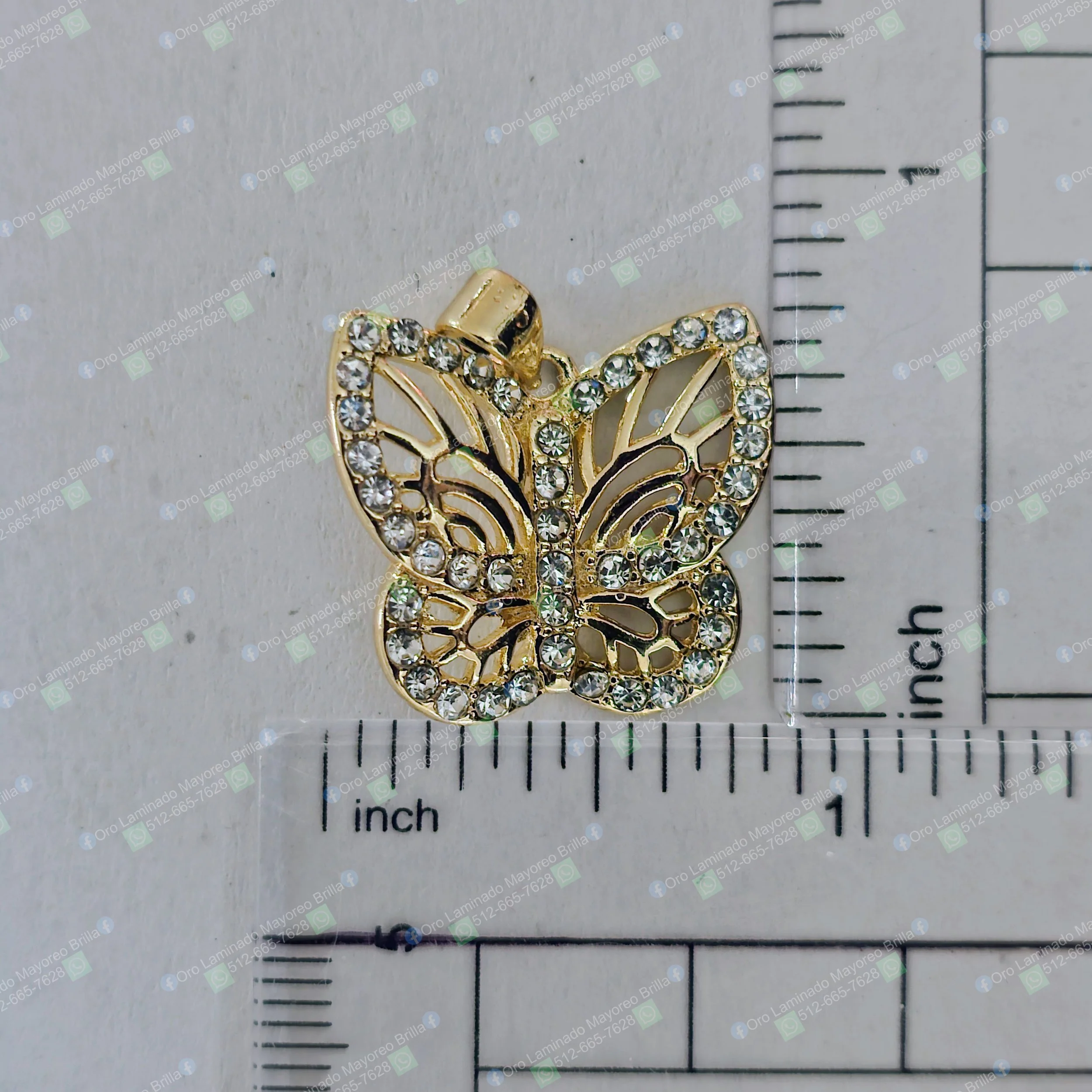 Dije de mariposa color oro con piedras decorativas visibles en diseño calado | Gold color butterfly pendant with visible decorative stones in openwork design
