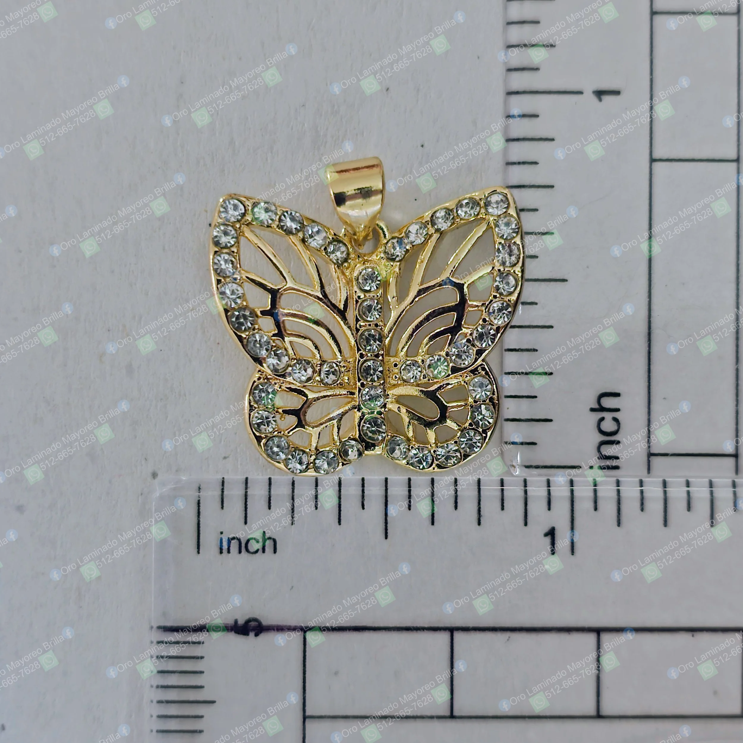 Dije de mariposa color oro con piedras decorativas visibles en bordes y cuerpo | Gold color butterfly pendant with visible decorative stones on edges and body