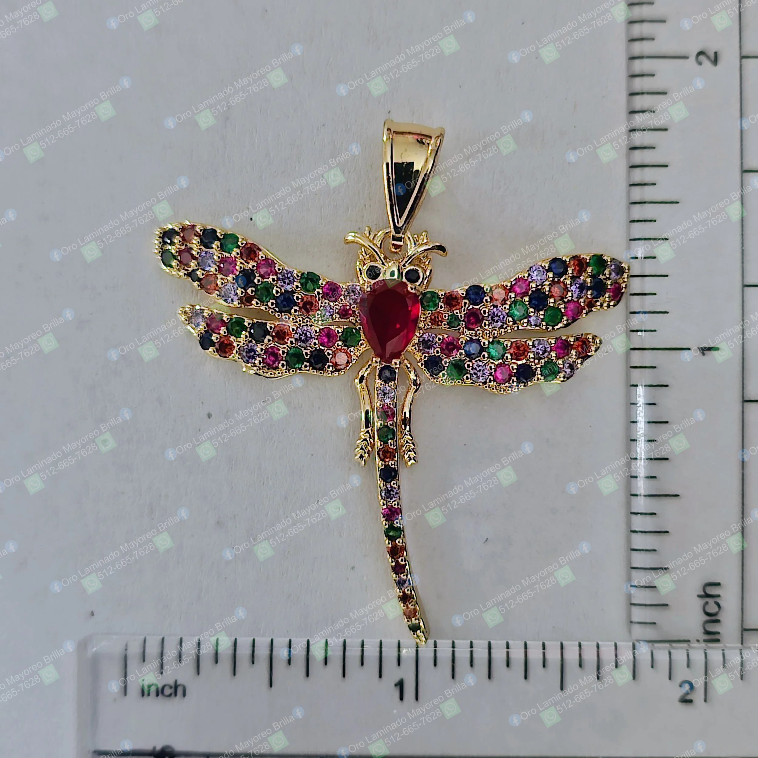 Dije de libélula color oro con piedras multicolor visibles y piedra roja en el centro | Gold color dragonfly pendant with visible multicolor stones and red stone centerpiece