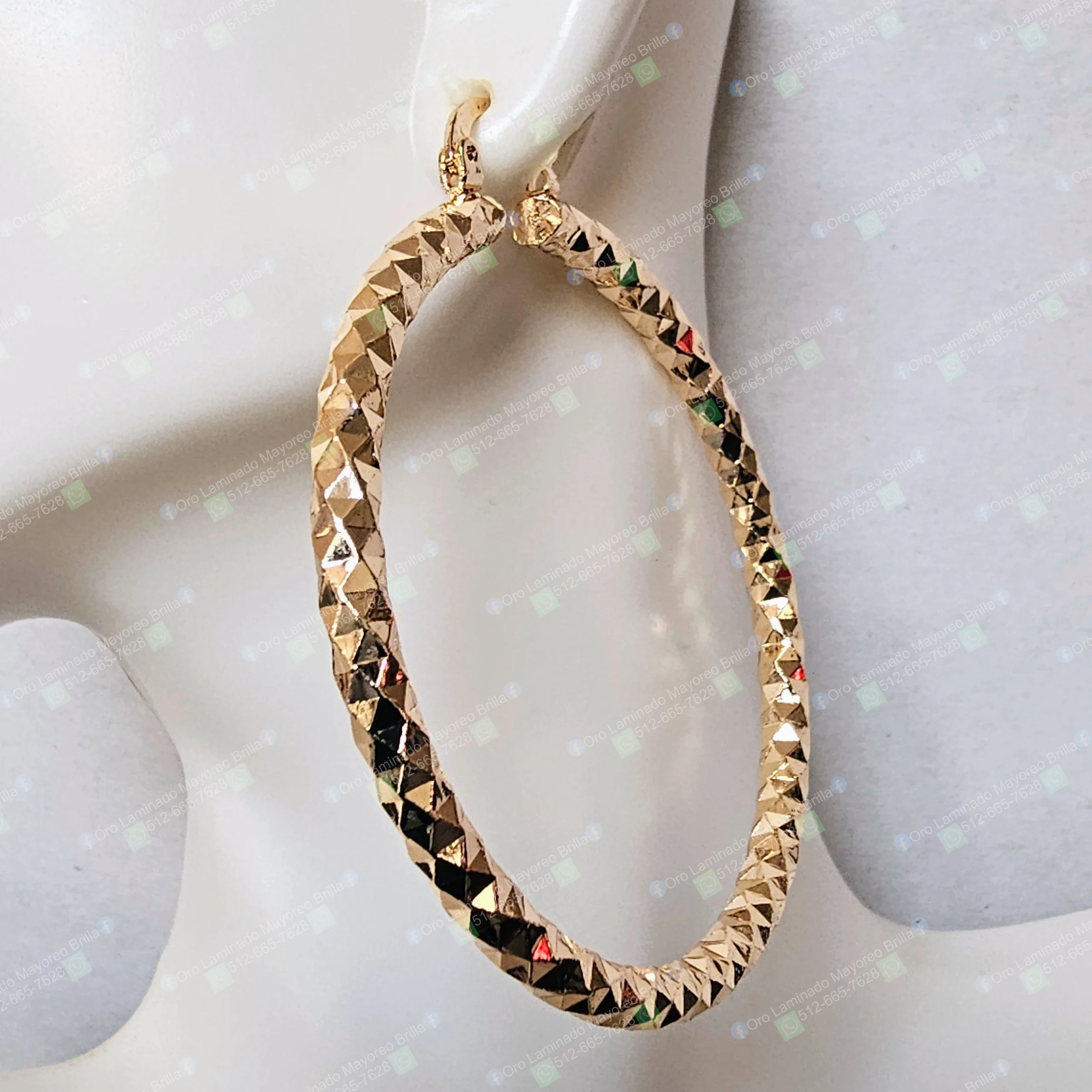 Aretes ovalados texturizados color oro con diseño reflectante visible | Textured gold color oval hoop earrings with visible reflective design