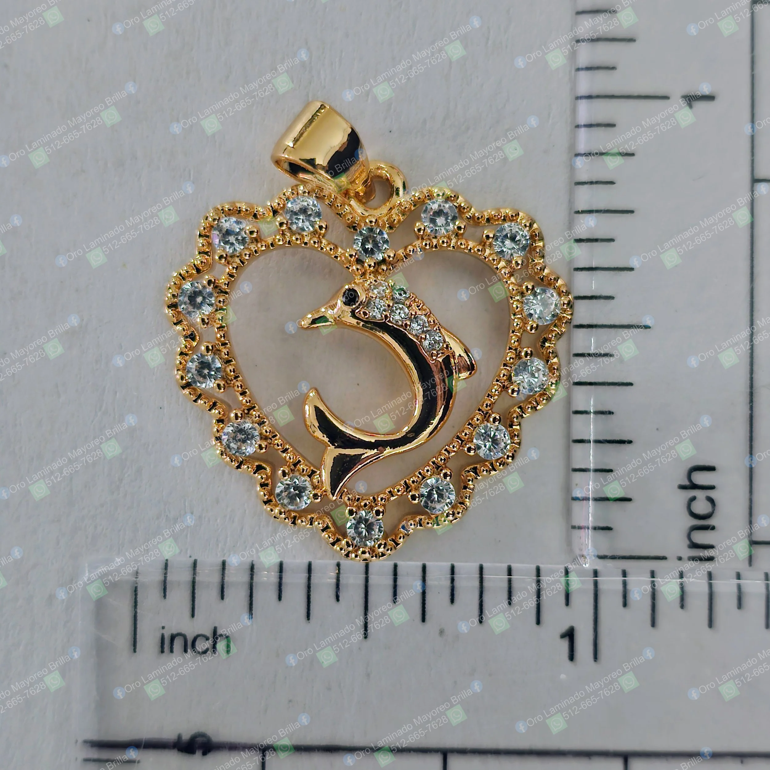Dije de delfin y corazon color oro con piedras decorativas visibles | Gold color dolphin and heart pendant with visible decorative stones