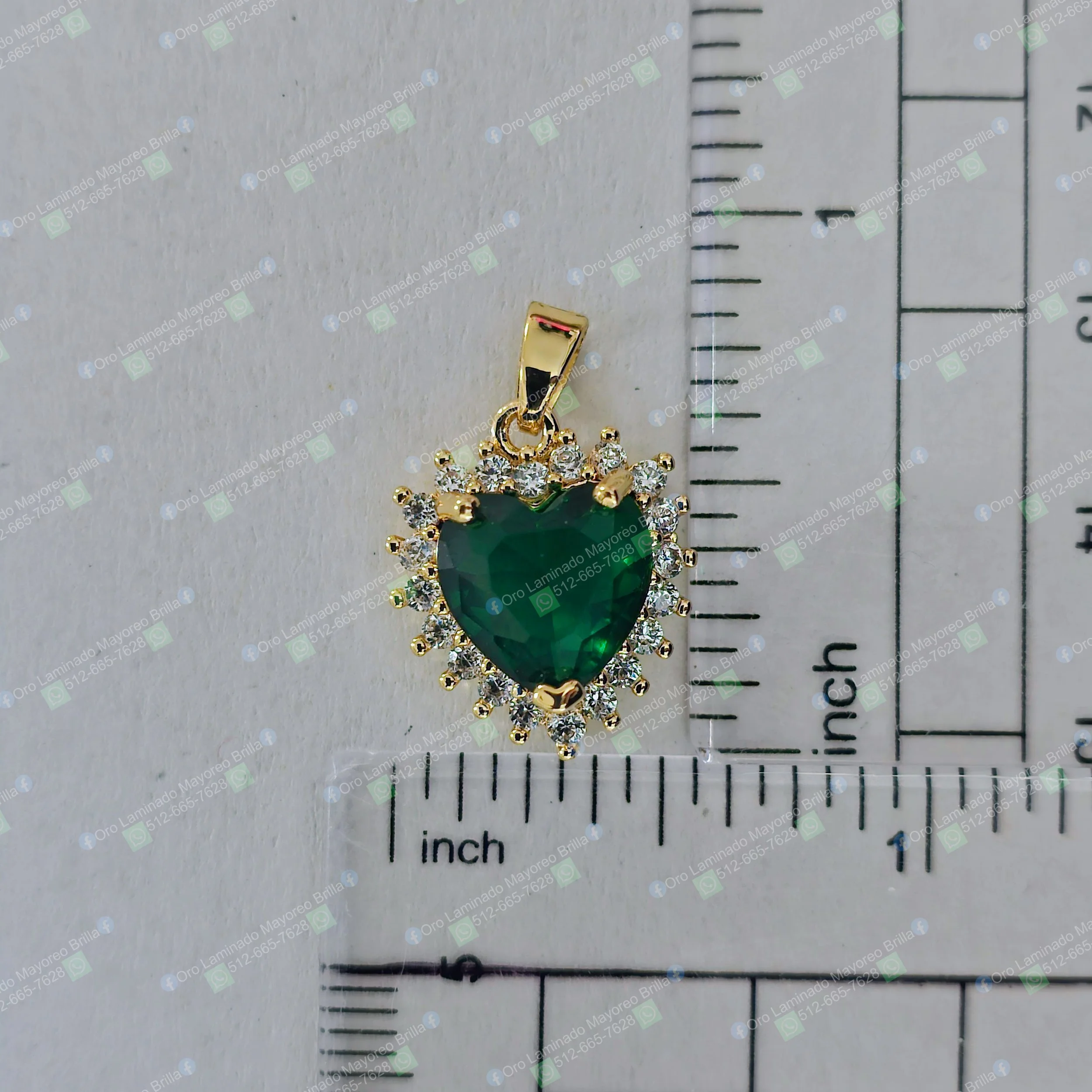 Dije corazon color oro con piedra verde central y piedras claras decorativas | Gold color heart pendant with central green stone and clear decorative stones