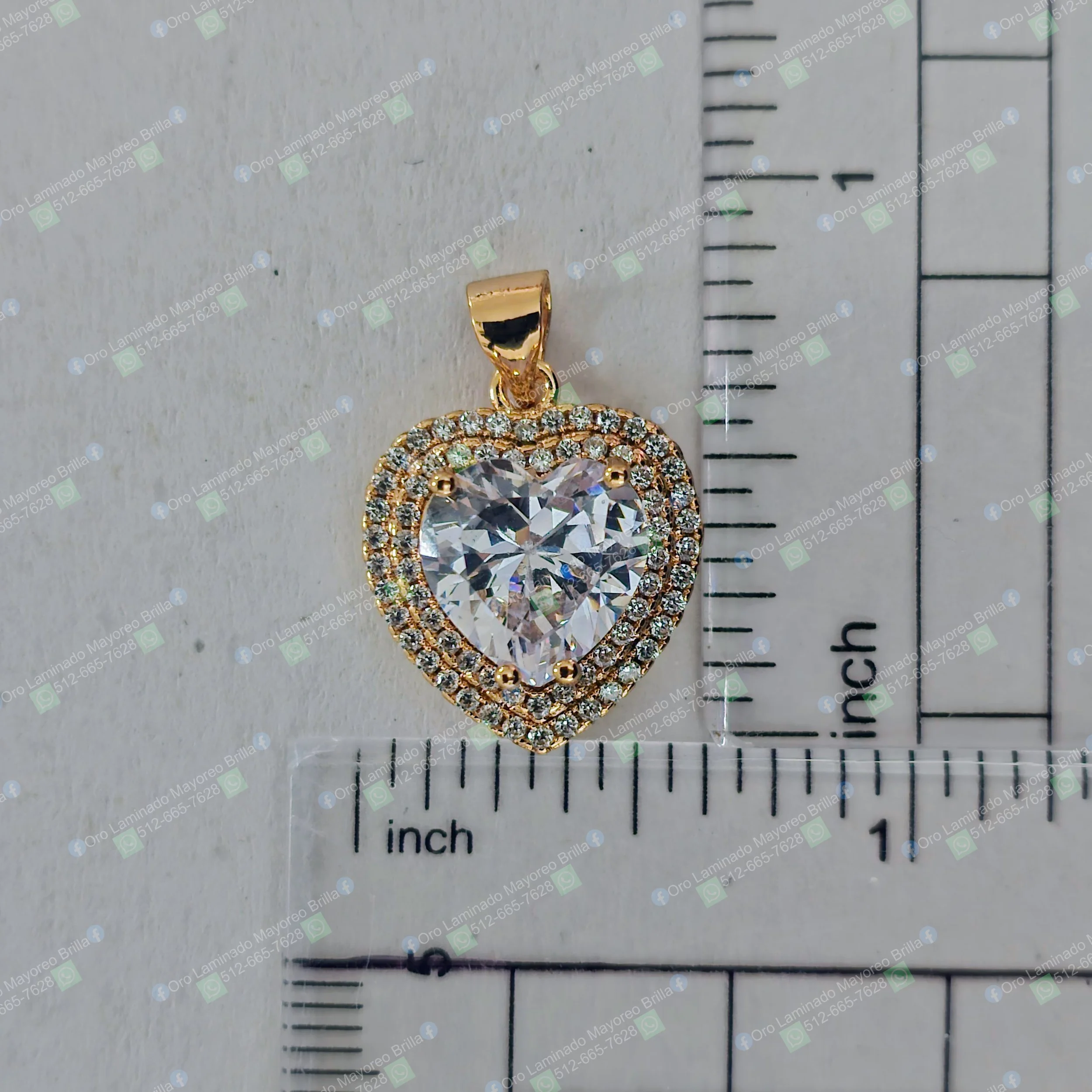 Dije corazon color oro con piedra central grande y piedras decorativas visibles | Gold color heart pendant with large central stone and visible decorative stones