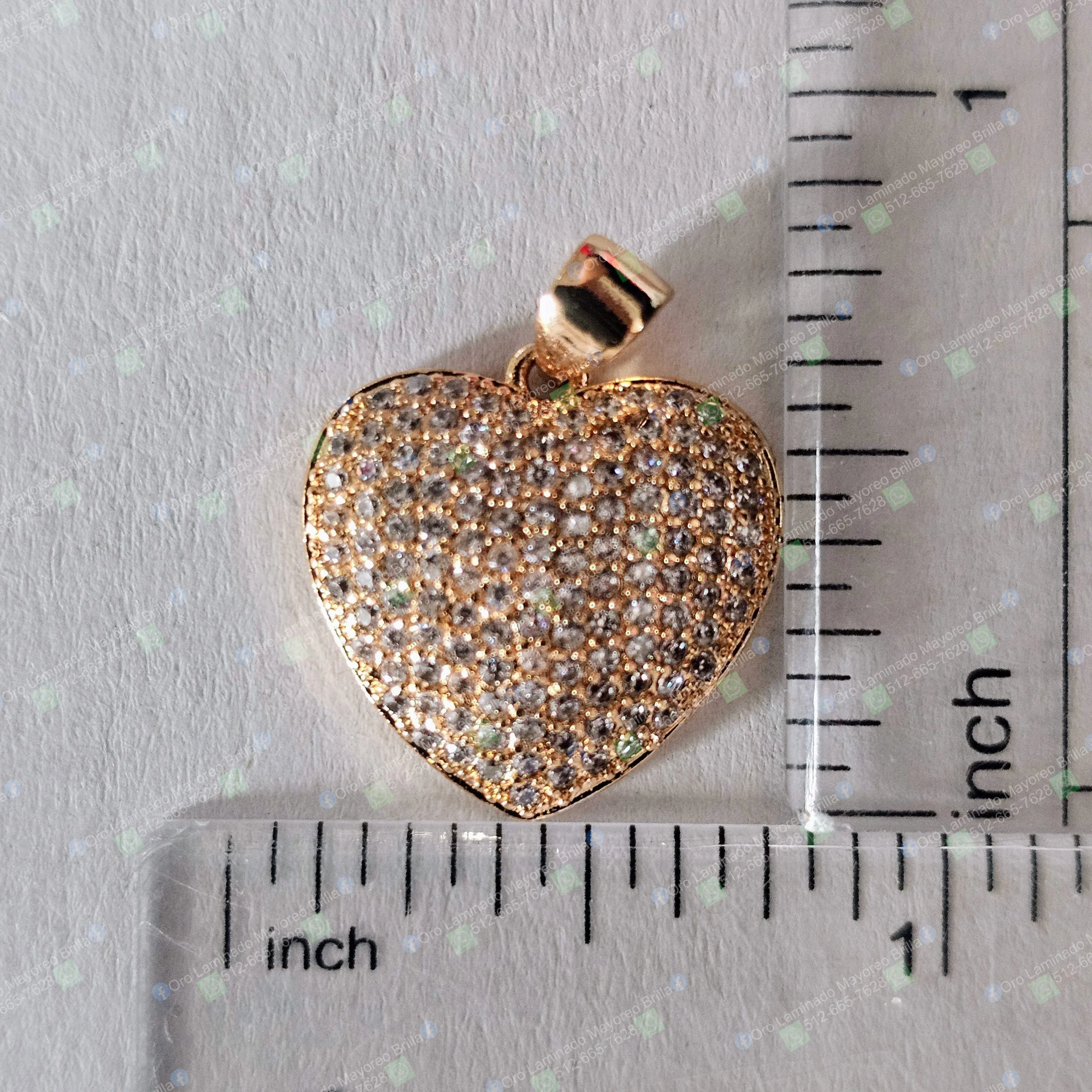 Dije de corazon color oro con piedras decorativas visibles y tamaño compacto | Gold color heart pendant with visible decorative stones and compact size