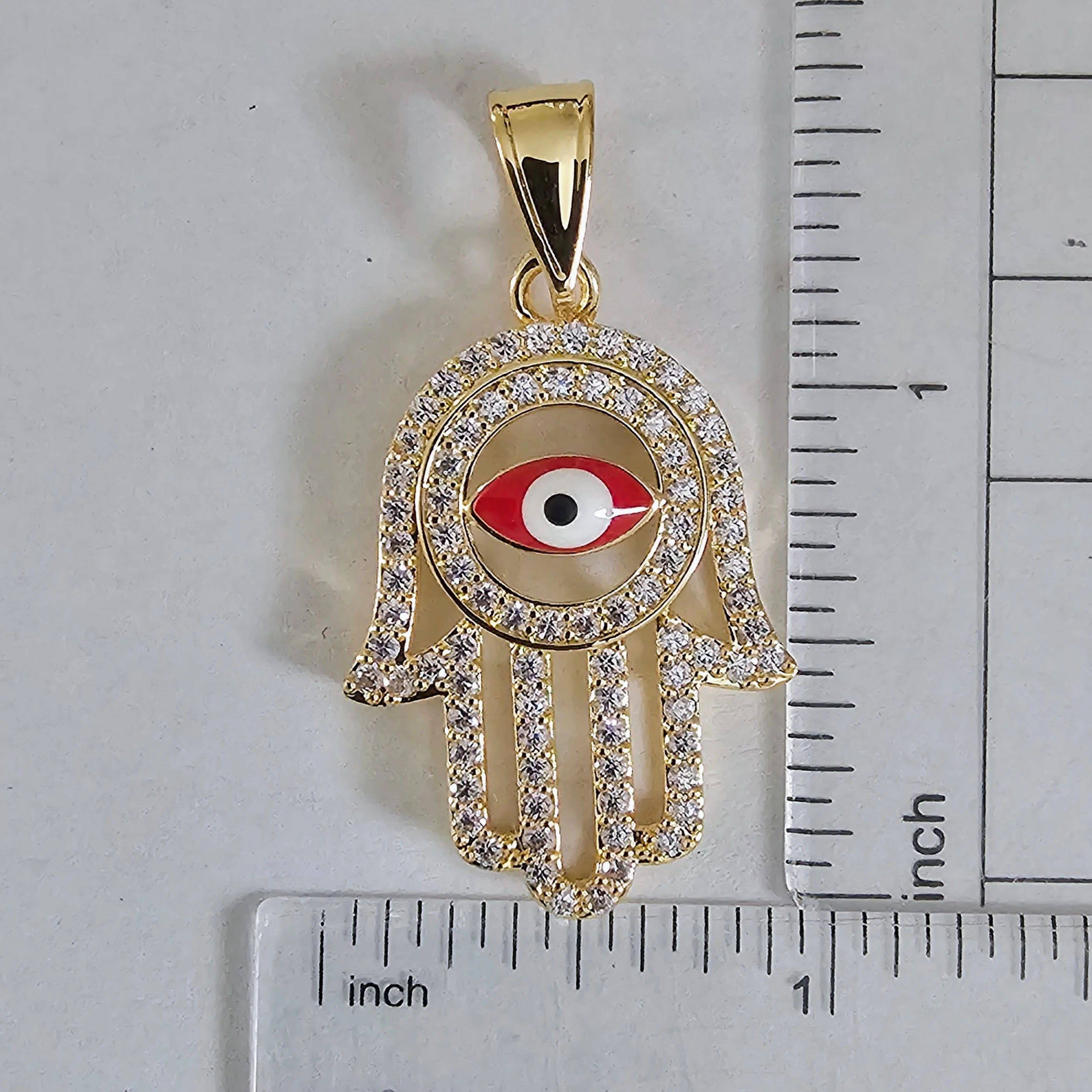 Dije de mano de ojo turco color oro con piedras decorativas visibles y | Gold color hamsa hand and eye of protection pendant with visible