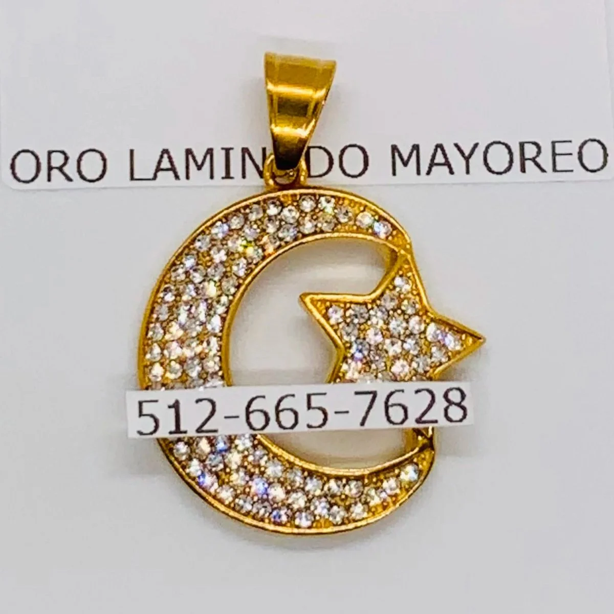 Dije de luna y estrella en acero inoxidable dorado. Gold-tone stainless steel moon and star pendant.
