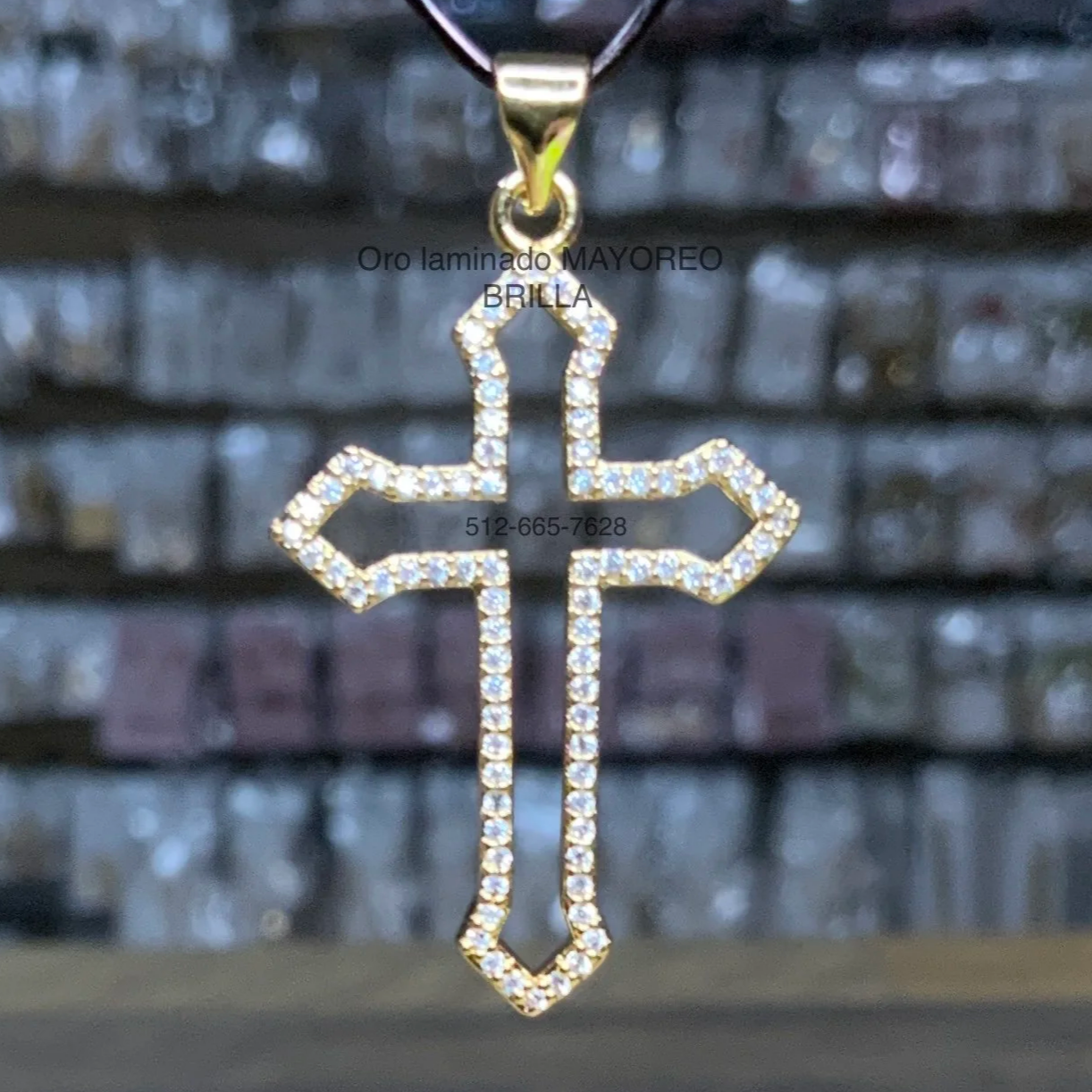 Cruz hueca decorada con piedras brillantes en oro laminado. Hollow cross with sparkling stones in laminated gold.