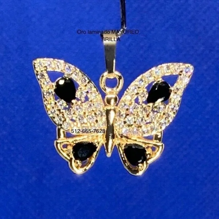 Dije de mariposa en oro laminado con piedras negras. Gold layered butterfly pendant with black gemstones.