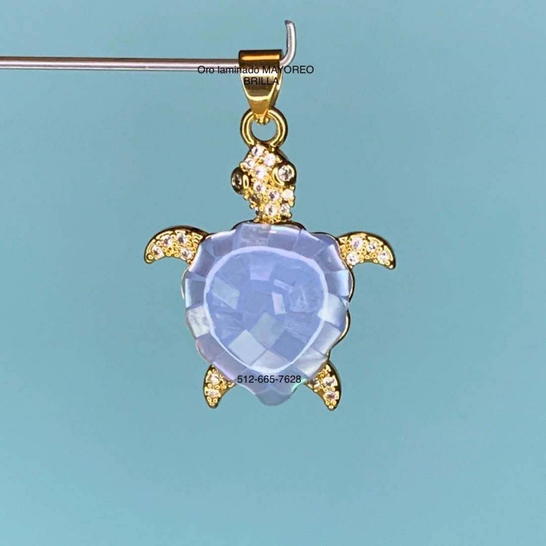 Dije de tortuga azul en oro laminado con concha facetada. Blue turtle pendant in gold with faceted shell.