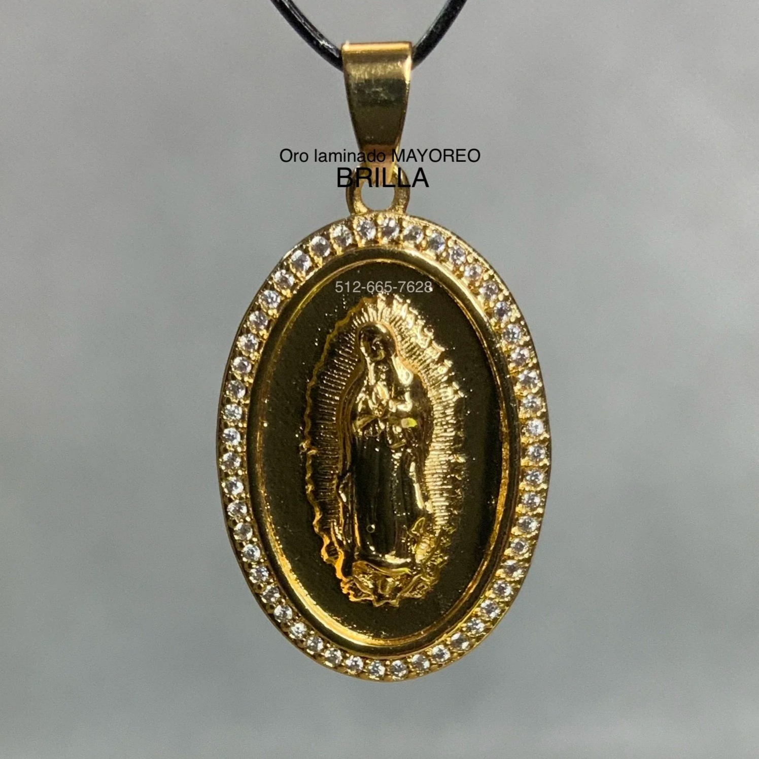 Dije ovalado dorado con la imagen de la Virgen de Guadalupe y marco de circonias blancas. Gold Guadalupe pendant with white zirconia oval frame.