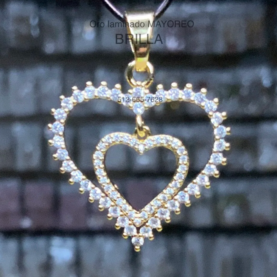 Dije de doble corazón en oro laminado con piedras. Laminated gold double heart pendant with crystal accents.