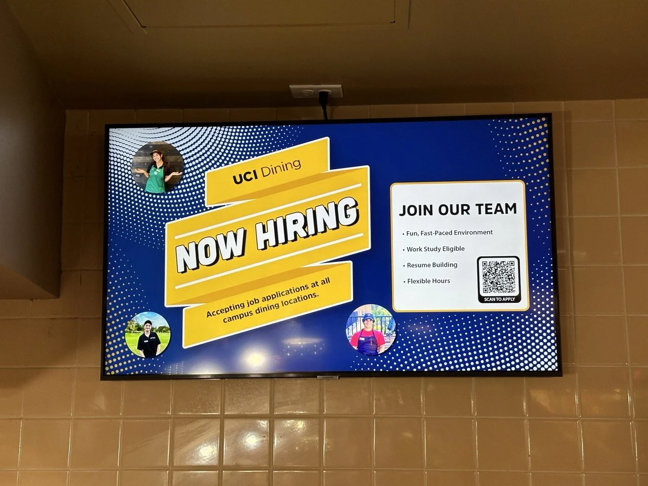 Digital sign announcing now hiring for UCI Dining, with photos of employees, and a section inviting applications with a QR code for scanning.