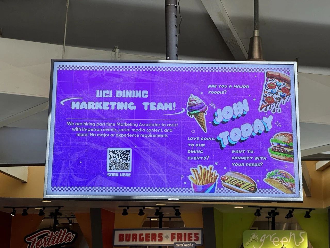 Digital sign promoting part-time marketing associate positions for UCI dining, with colorful foods like pizza, burger, fries, and ice cream; includes a QR code for application.