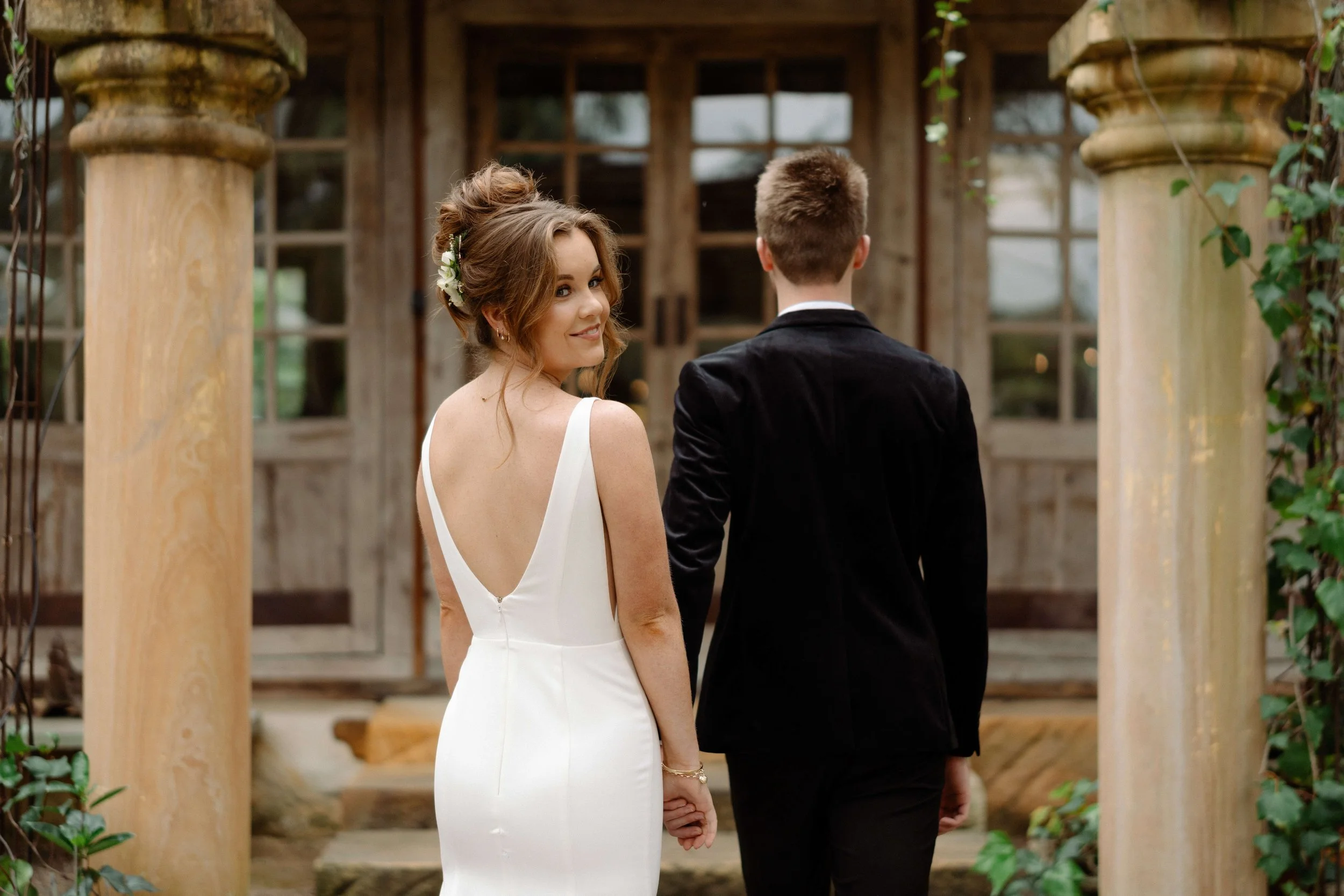 Couple framed by European-style colonnade at Leaves & Fishes