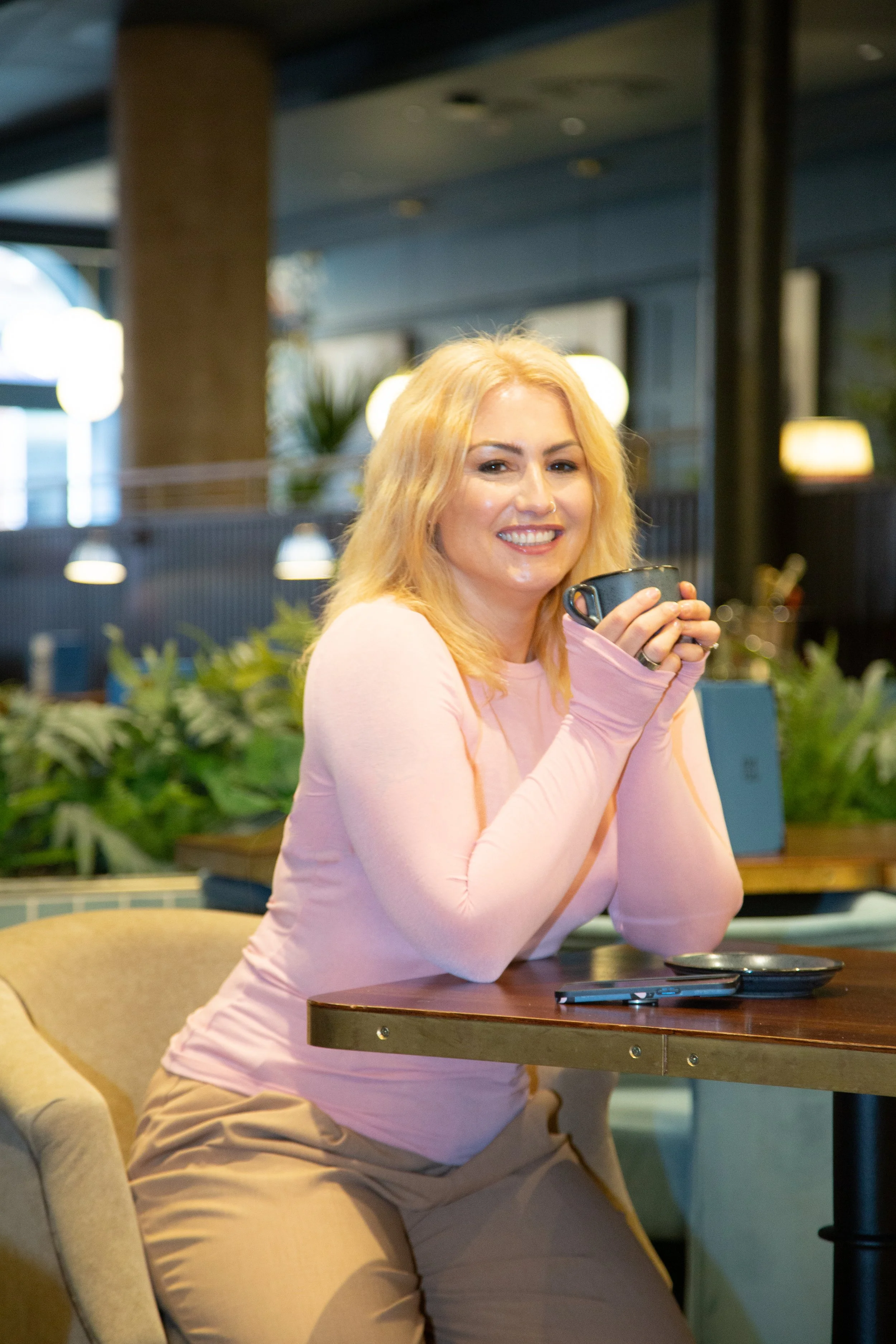 blone woman drinking coffee and smiling