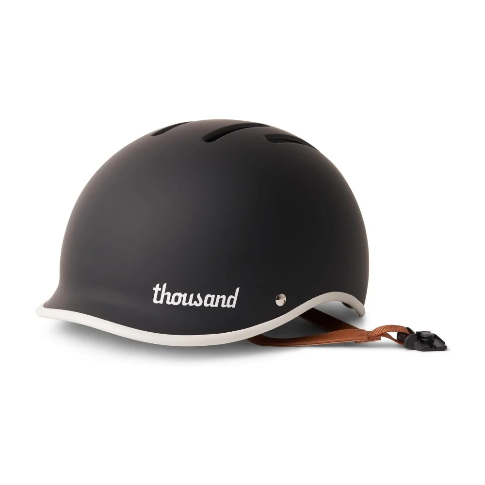 Thousand Heritage: Matte black low-profile bike helmet with brown strap designed for everyday riders and comfortable daily use.