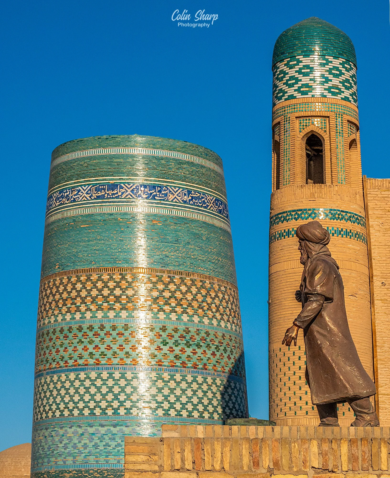 Golden hour image of the Kalta Minor Minaret with the ruler Temir in the foreground.