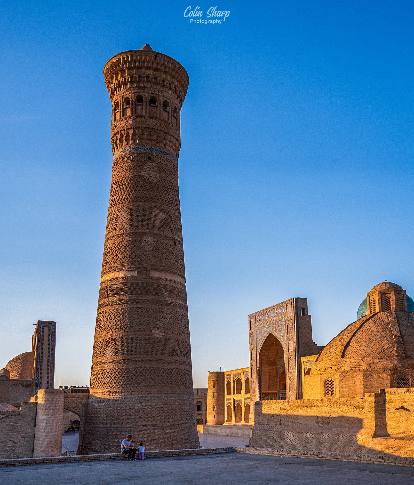 An evening golden hour image of the 47m tall Kalon Minaret in Bukhara which has stood for the past nine centuries. The Kalon complx and Mir-i Arab Medressa are behind it.