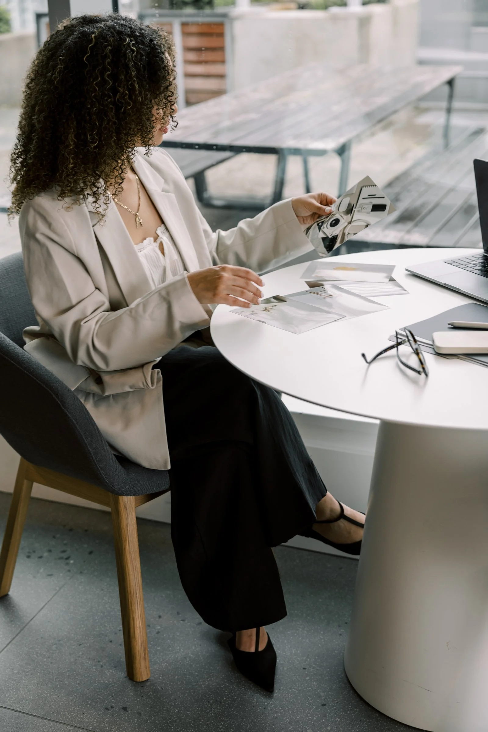 Designer sorting through mood board photos while seated in a co-work space