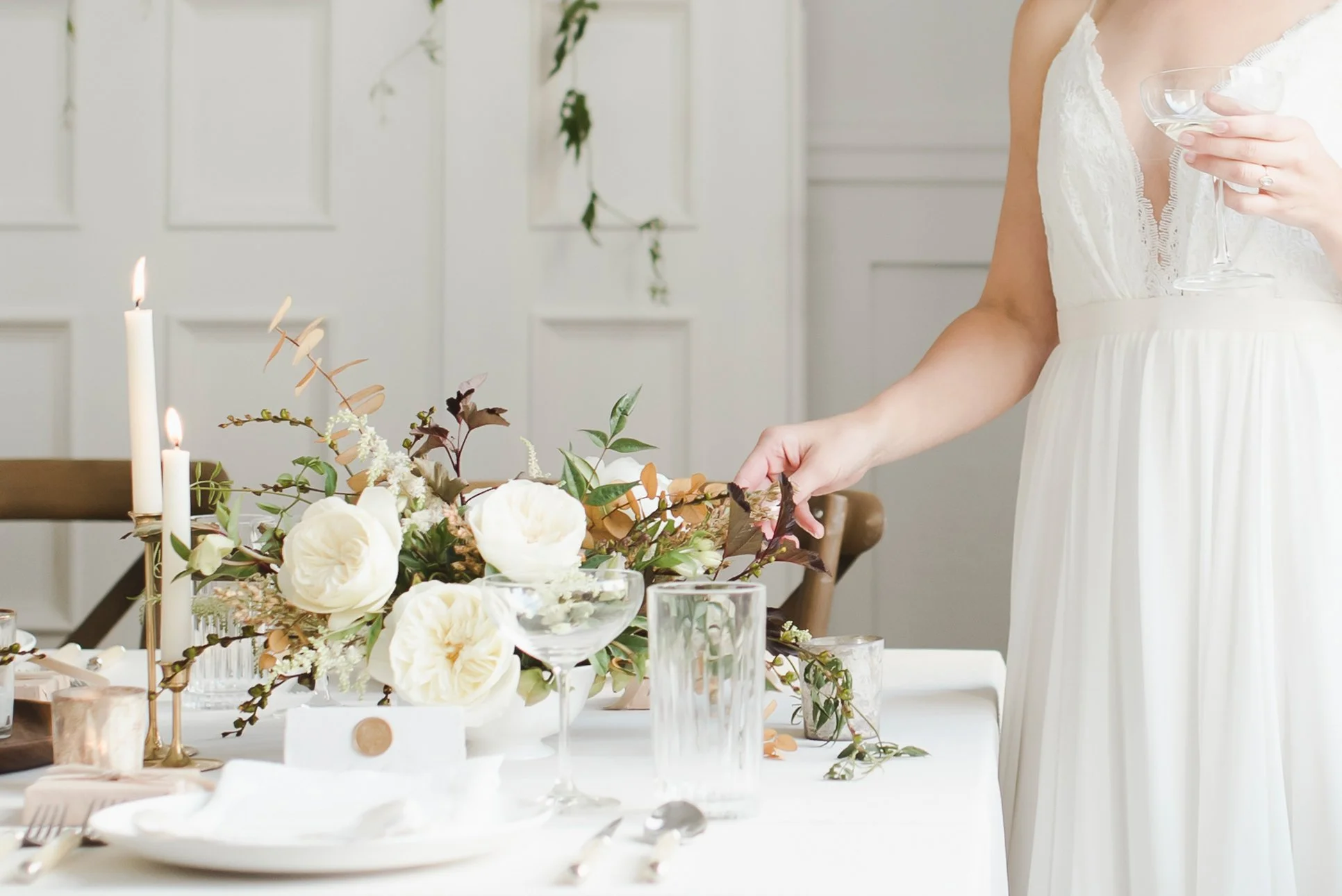 Bride adjusting flowers on table