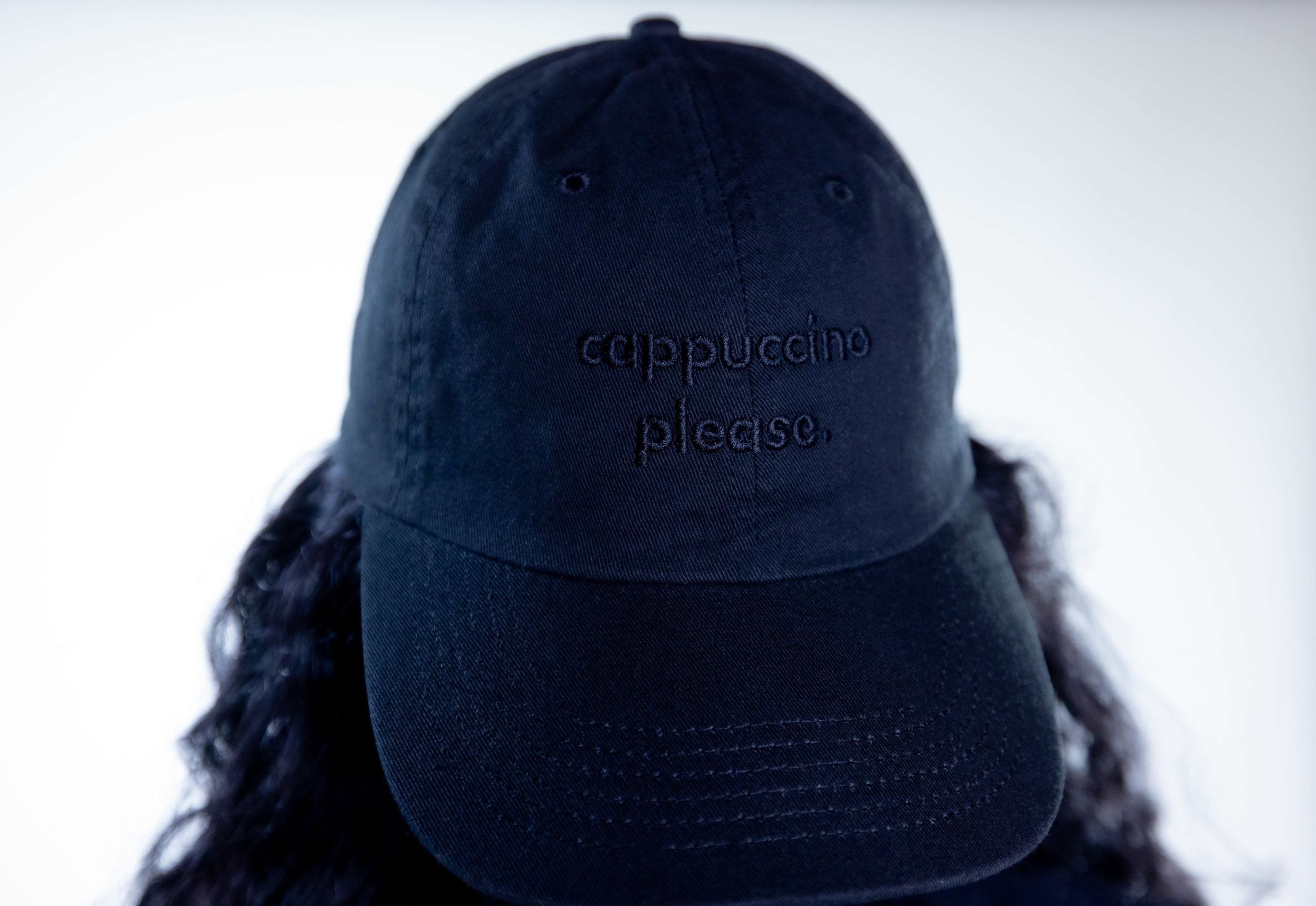 Woman wearing Capuccino please hat black hat