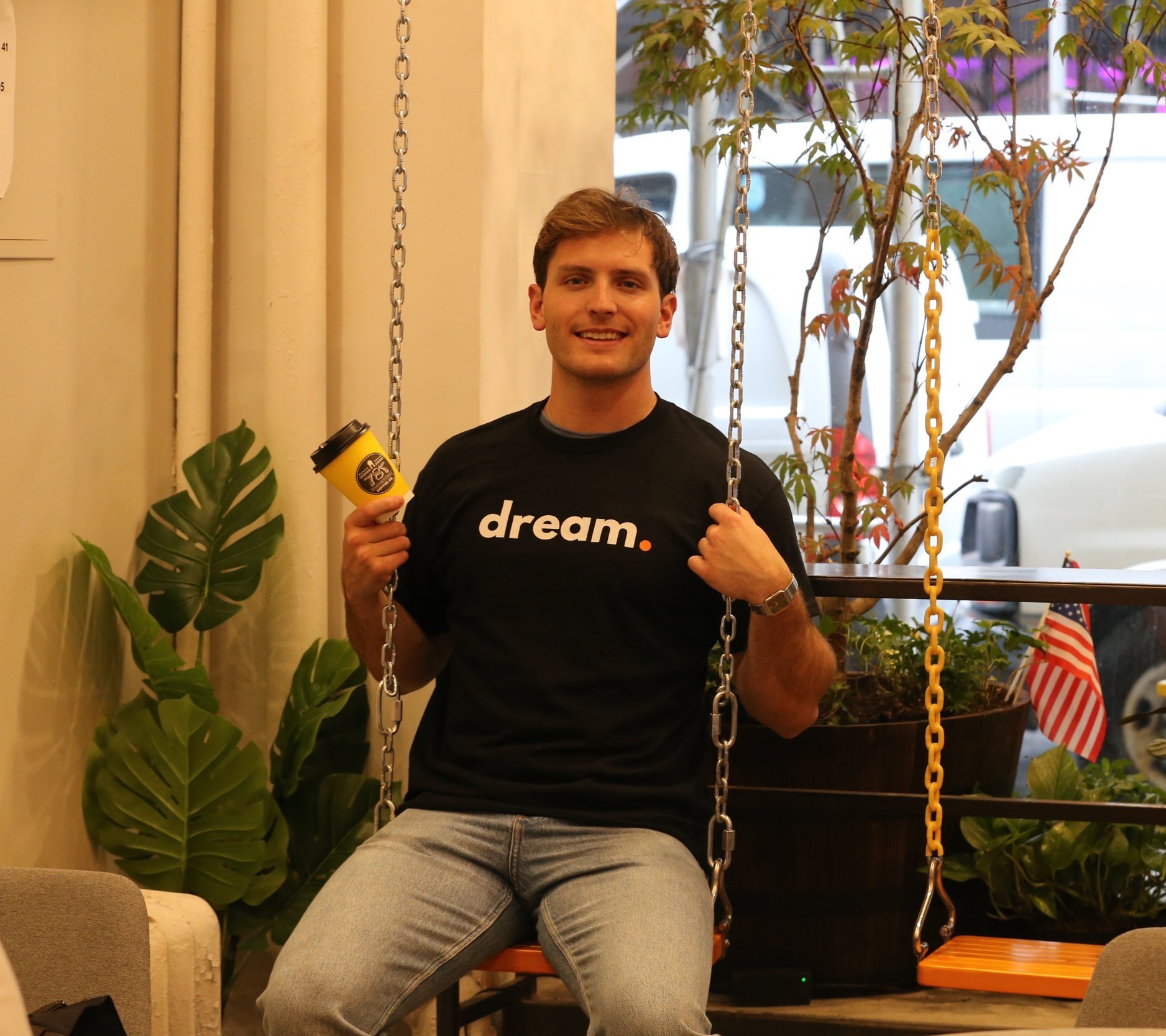 man wearing the dream t-shirt on a swing