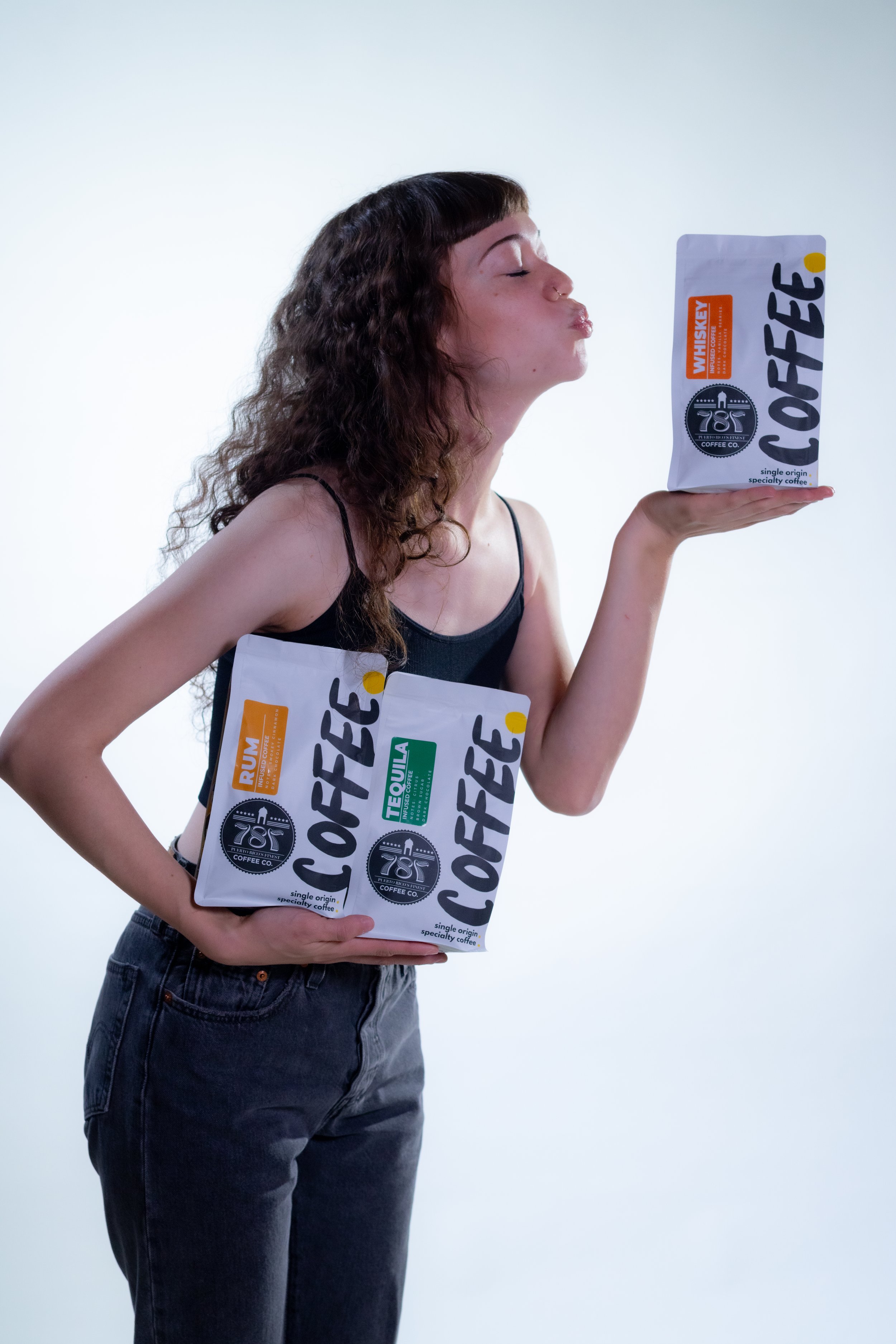 Girl carrying the trio infused coffee beans and throwing a kiss to a bag