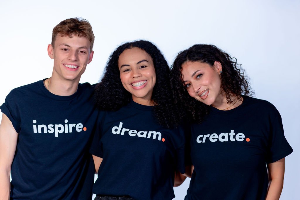 one male wearing the inspire. t shirt, female wearing dream.t shirt and another female wearing create. by 787 coffee
