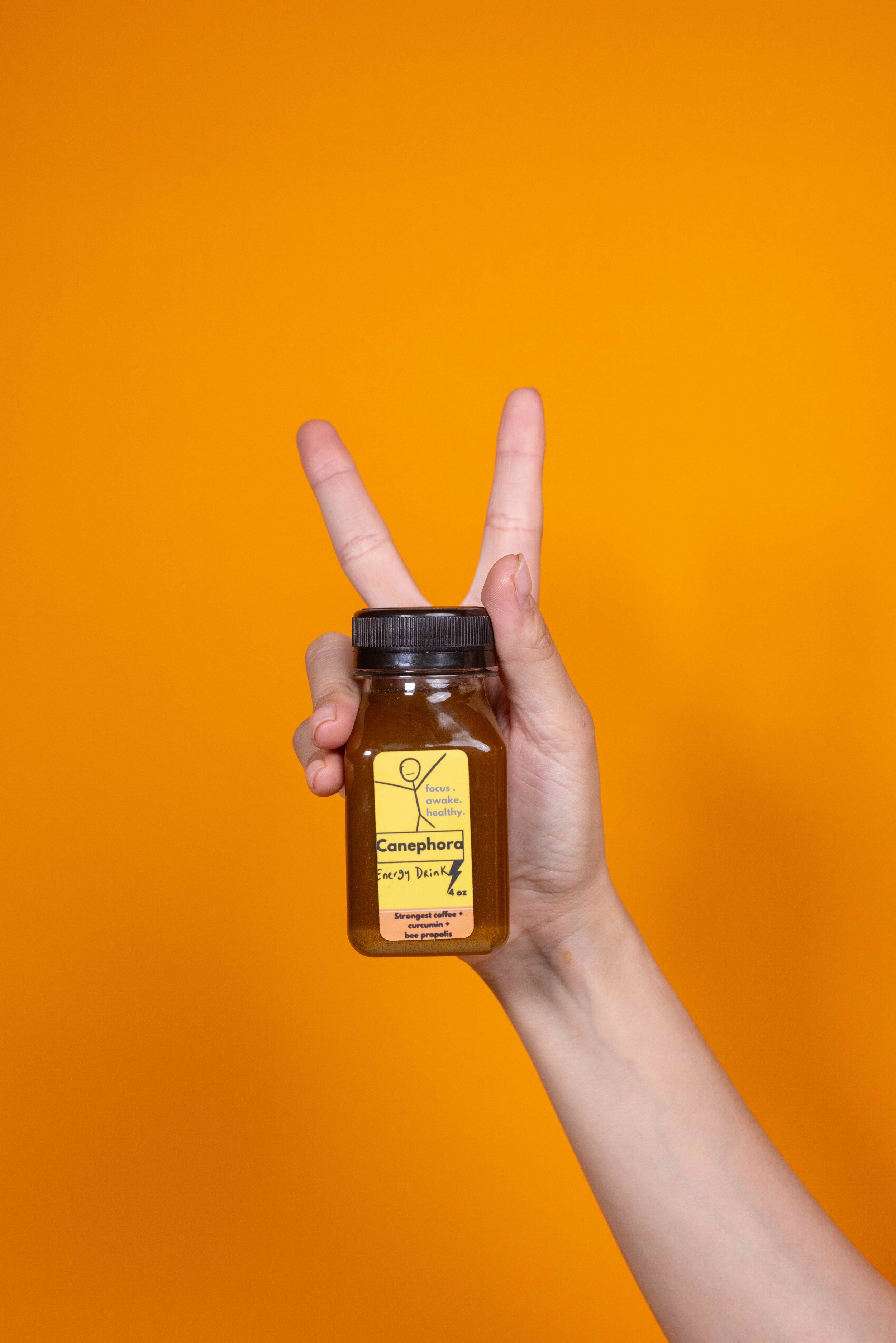 Canephora single bottle with one hand holding the bottle
