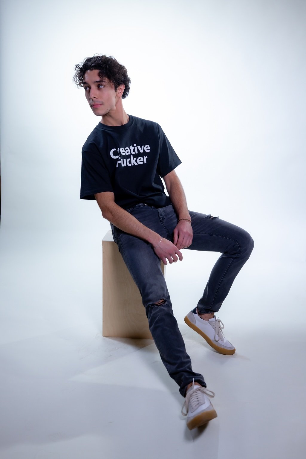 Male sitting down wearing Creative Fucker T shirt