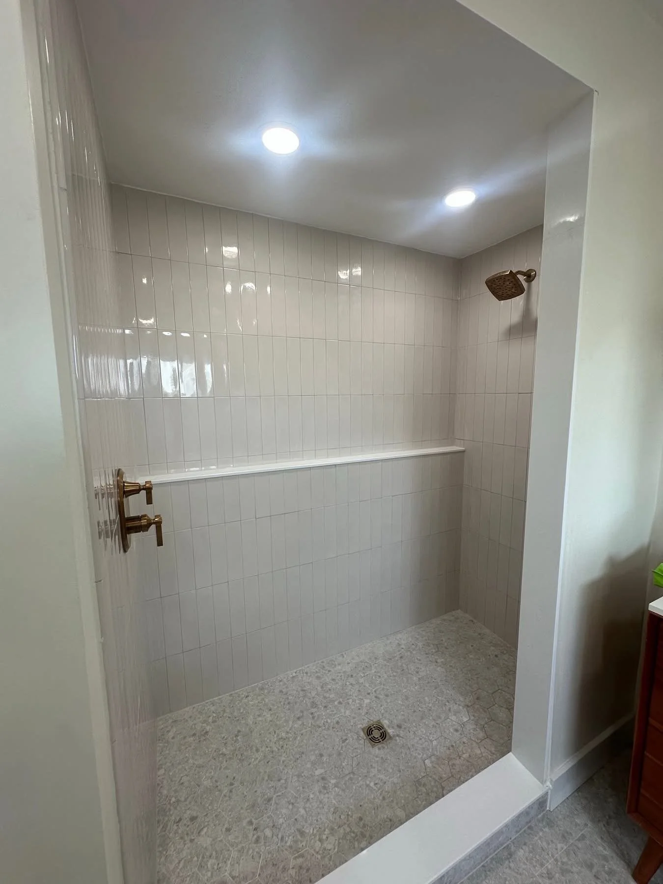 Shower stall view for a complete bathroom renovation. Shower doors were installed after this photo was taken. Note the full length ledge, this was custom requested over our standard shower niche. 