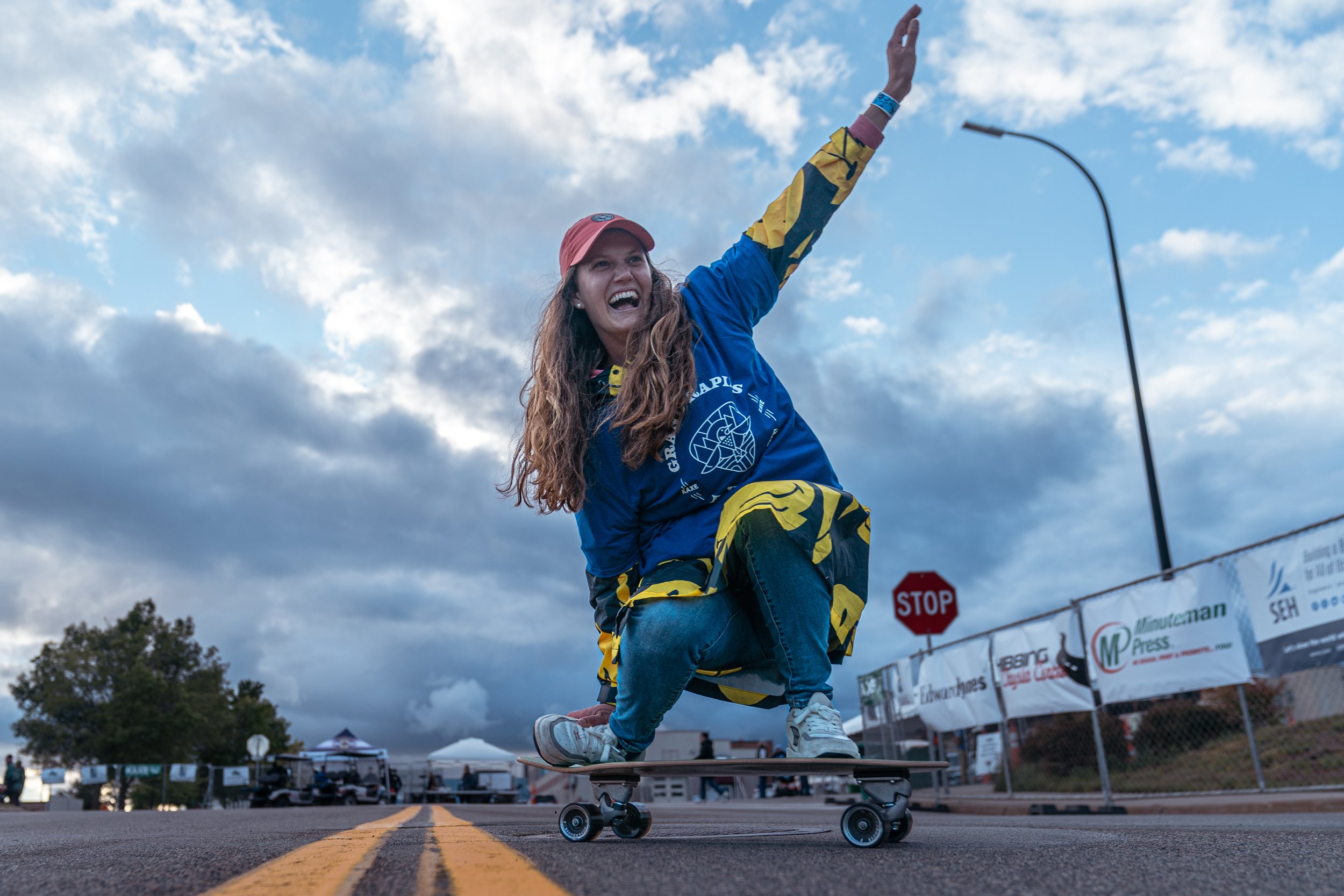 Volunteer Michelle Bedford skateboards down the street.jpg