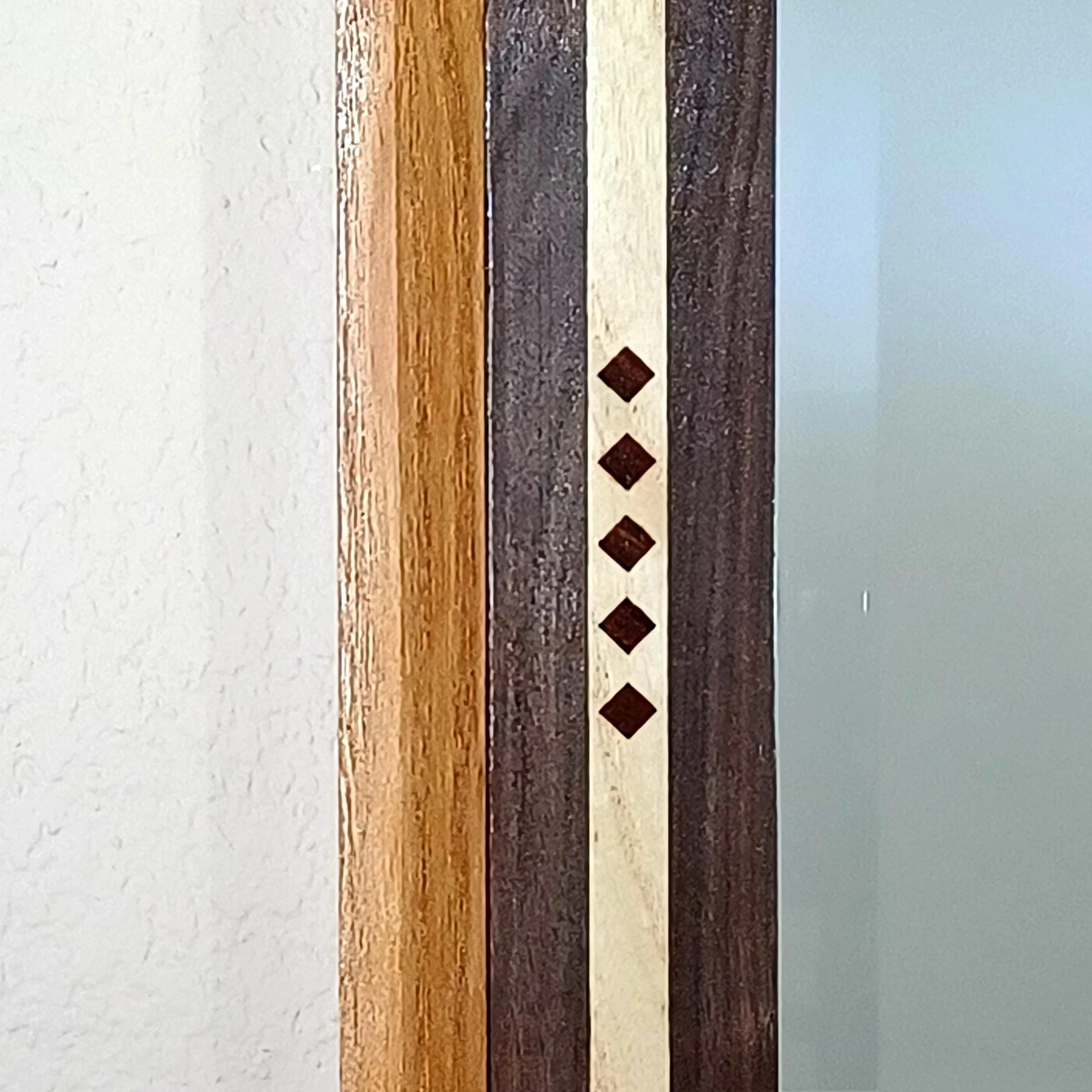 "Diamond" shaped Teak accents in a mirror's frame.