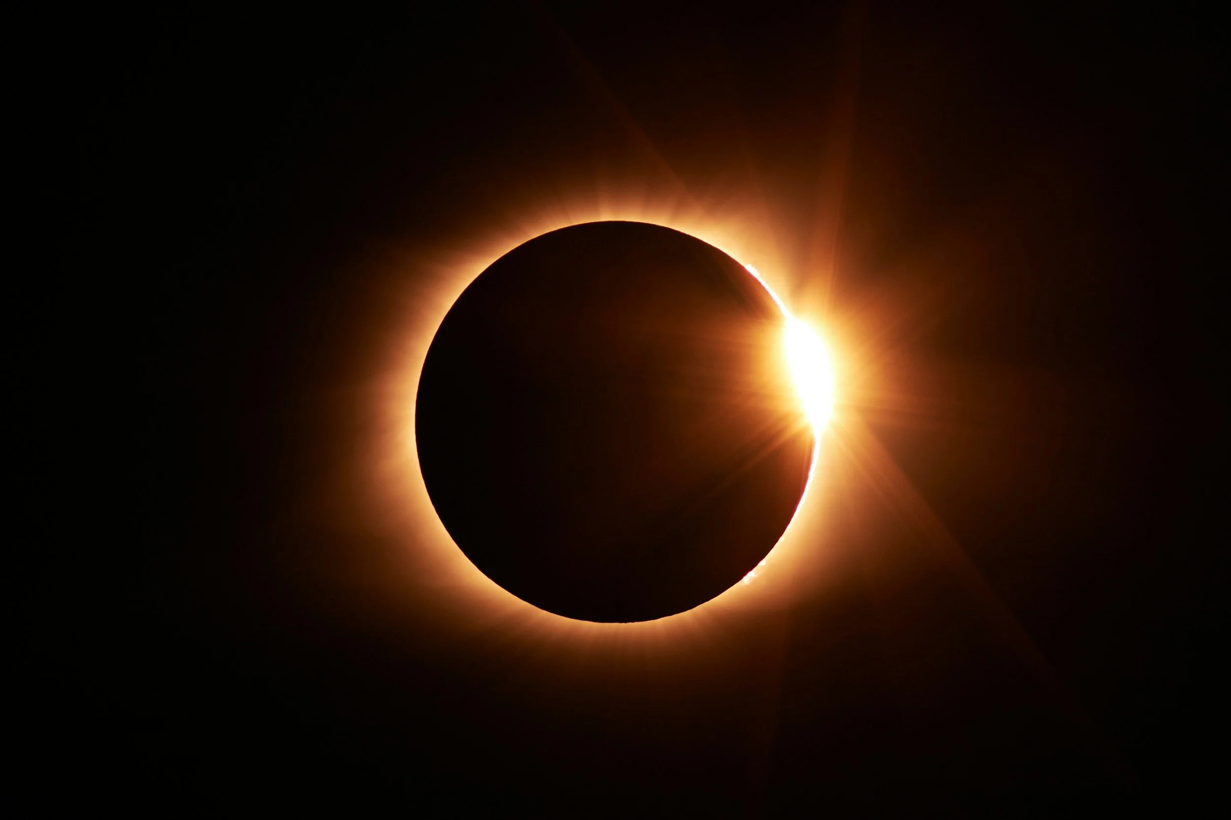 A solar eclipse where the moon is covering the sun, creating a glowing ring of light around the moon.