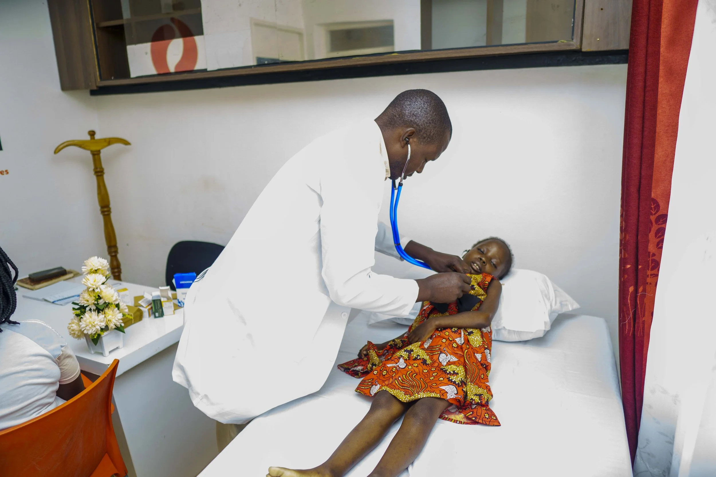 Doctor examining a young child during a sickle cell disease health assessment.