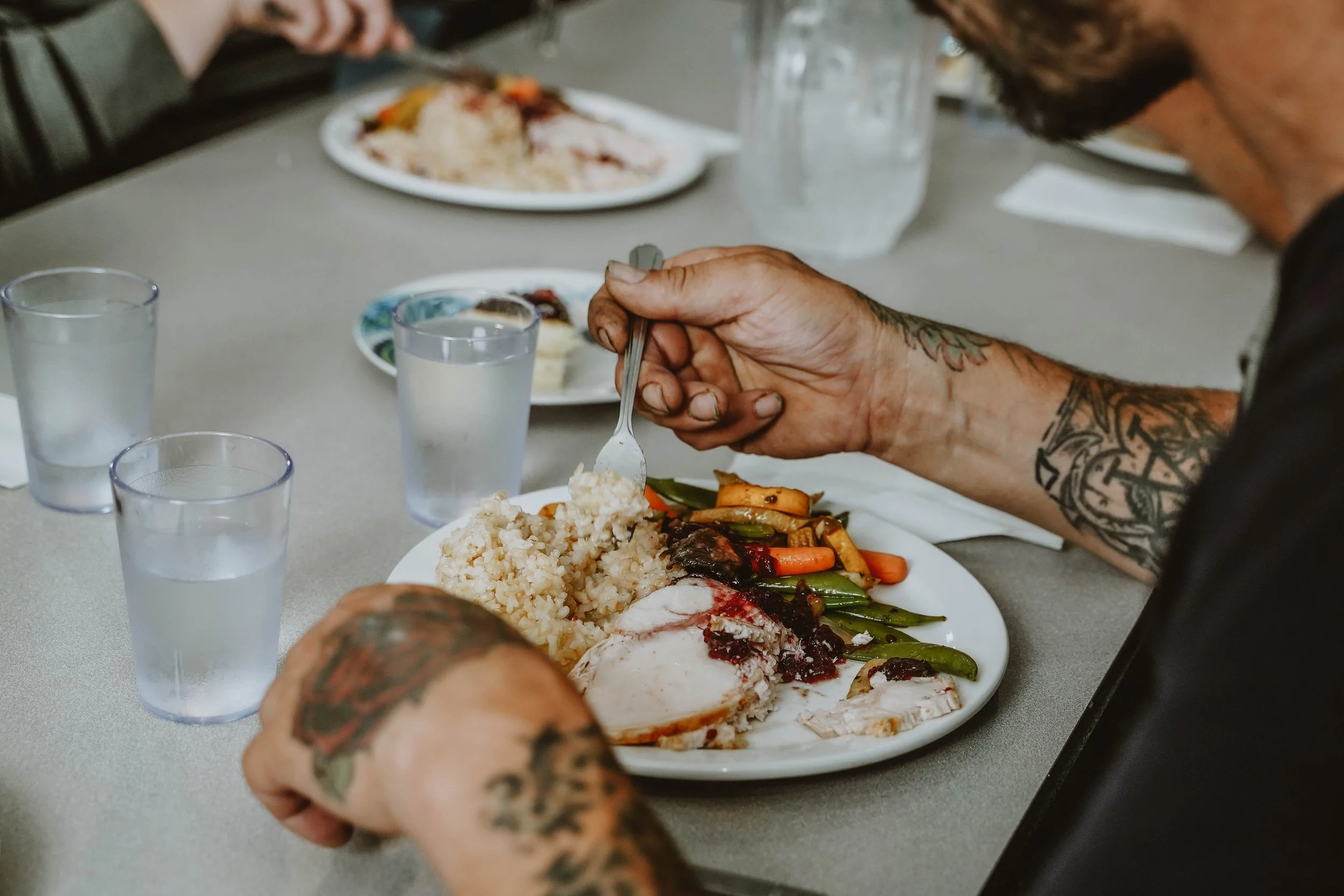 a homeless man eats a meal at a shelter
