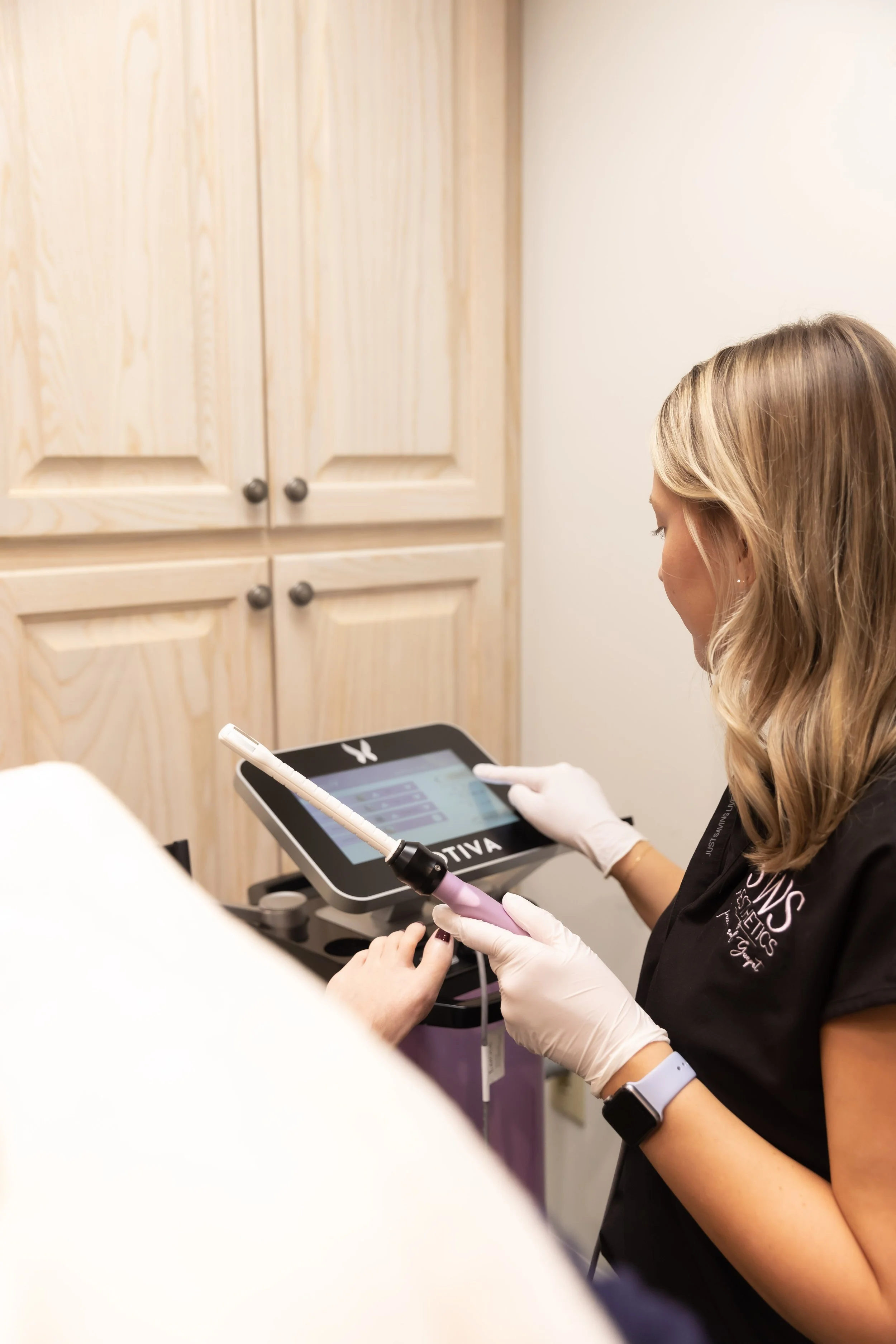 Aesthetician using a Votiva machine during a cosmetic procedure