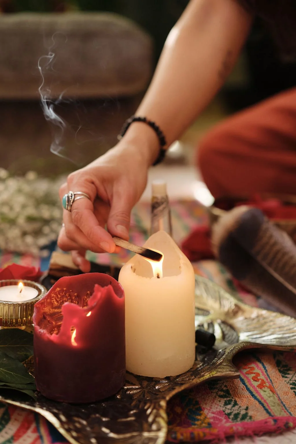 Igniting a palo santo stck with a white candle light.