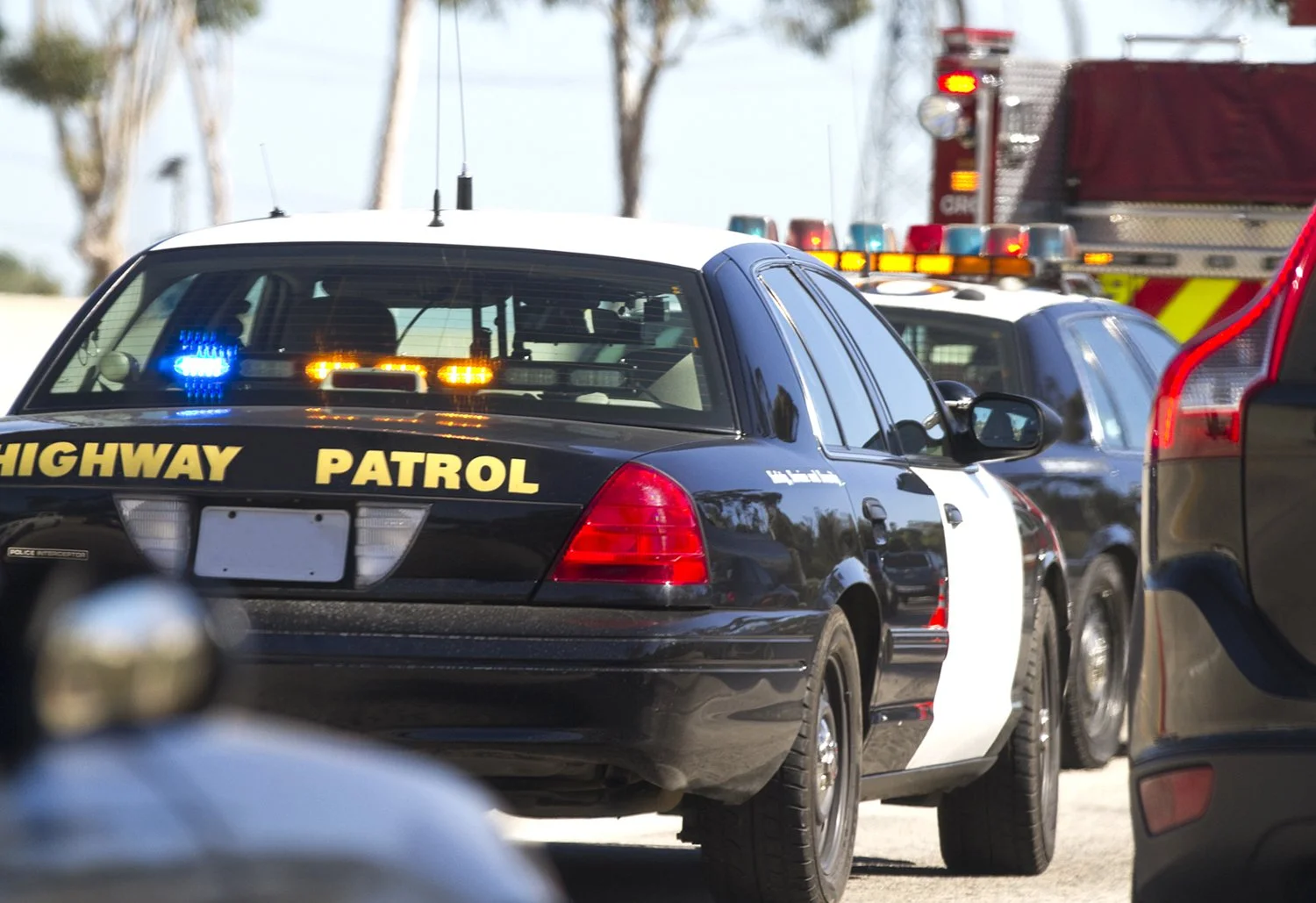Highway patrol cars and fire truck respond to roadside emergency