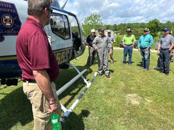 Alabama State Trooper helicopter on the ground with pilot speaking to GISAA event attendees.