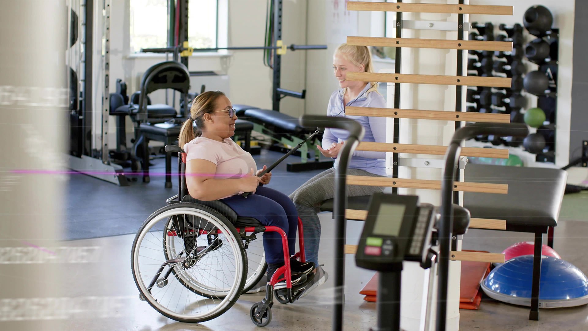 An adaptive athlete doing a seated banded row.