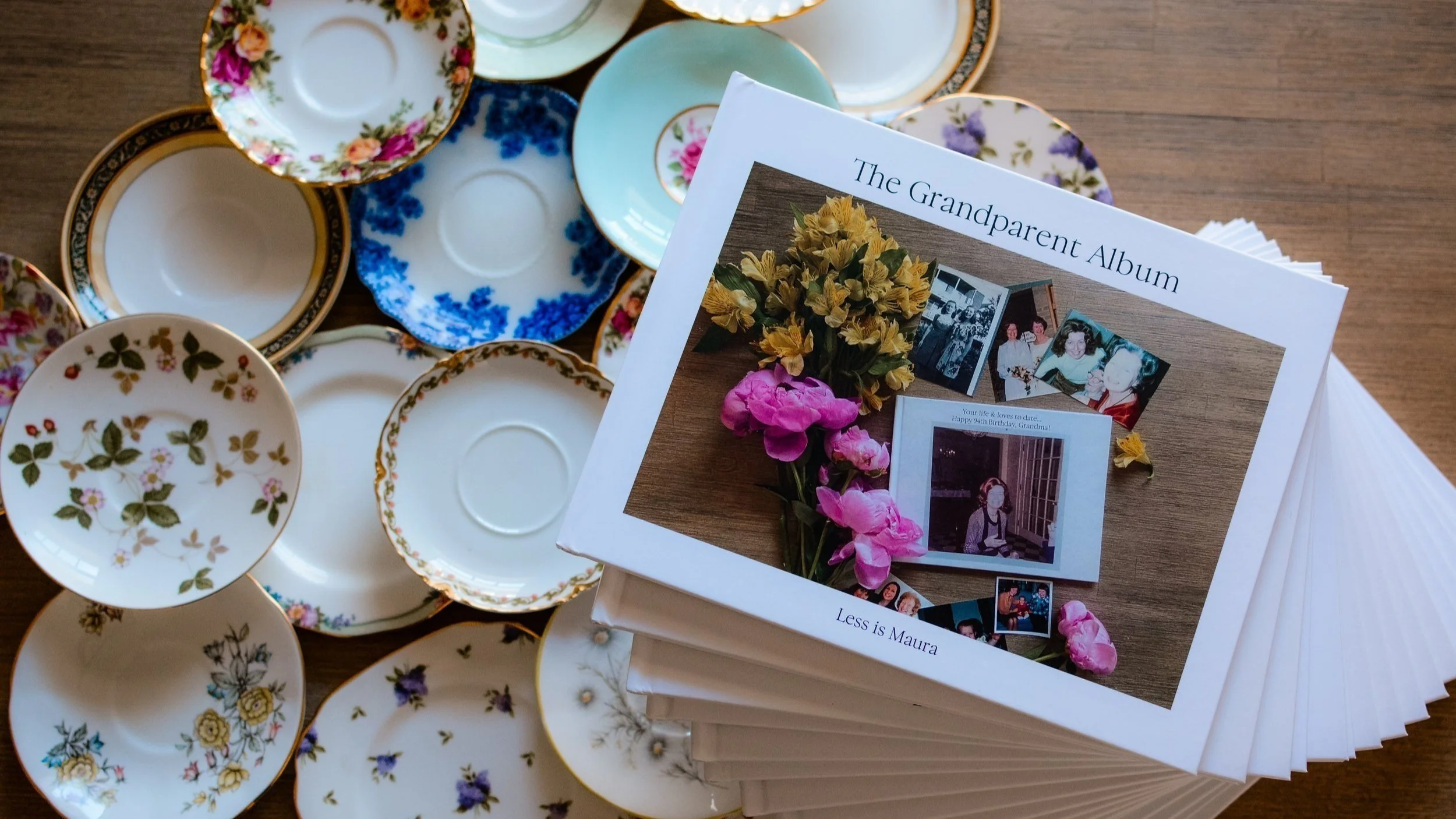 A stack of albums sits next two an assortment of colorful tea plates.