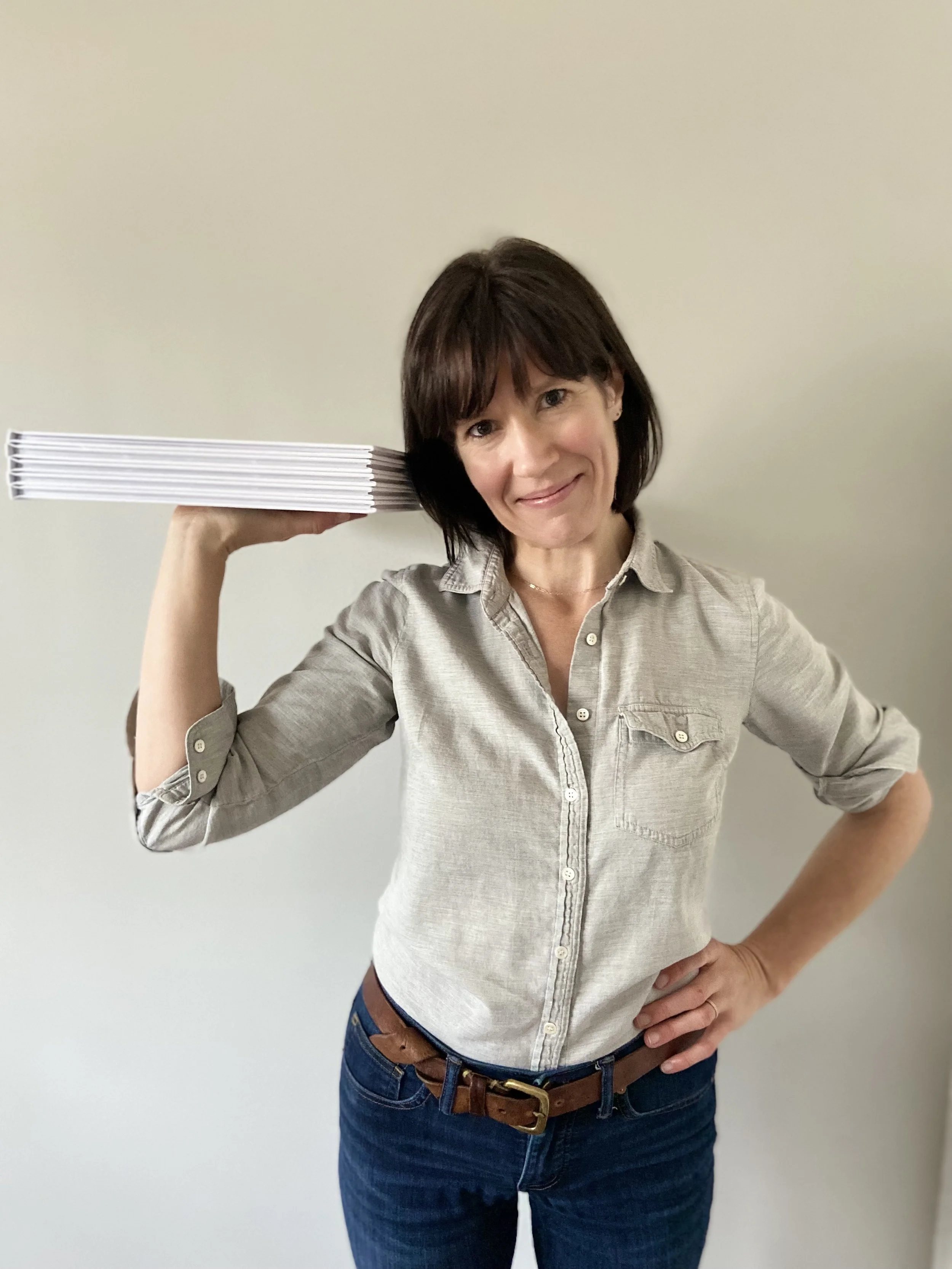 Maura Malloy proudly holds a stack of albums like a server's tray.