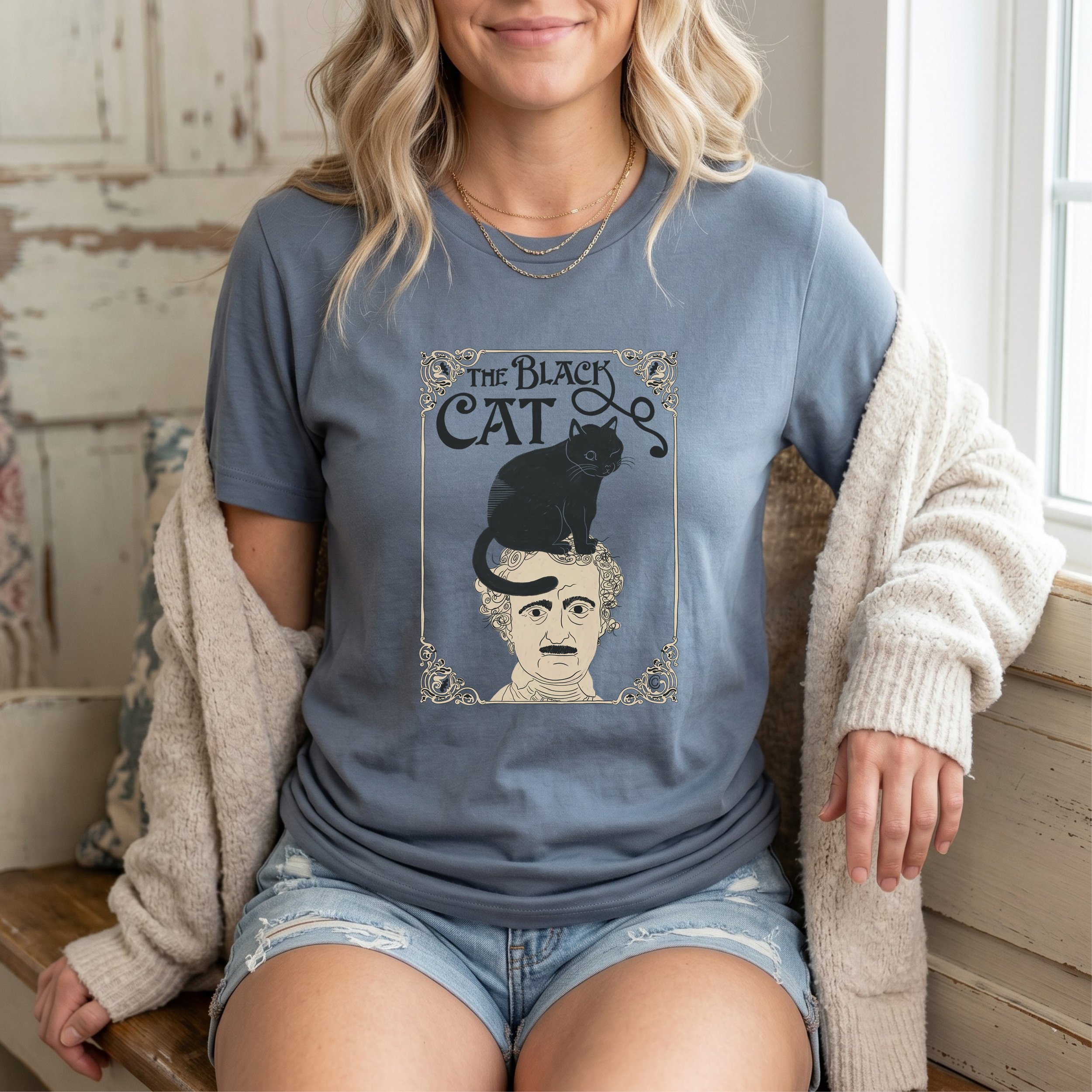 Woman wearing Carrie Cantwell's The Black Cat t-shirt, with a black cat perched on Edgar Allan Poe's head, sold on Etsy