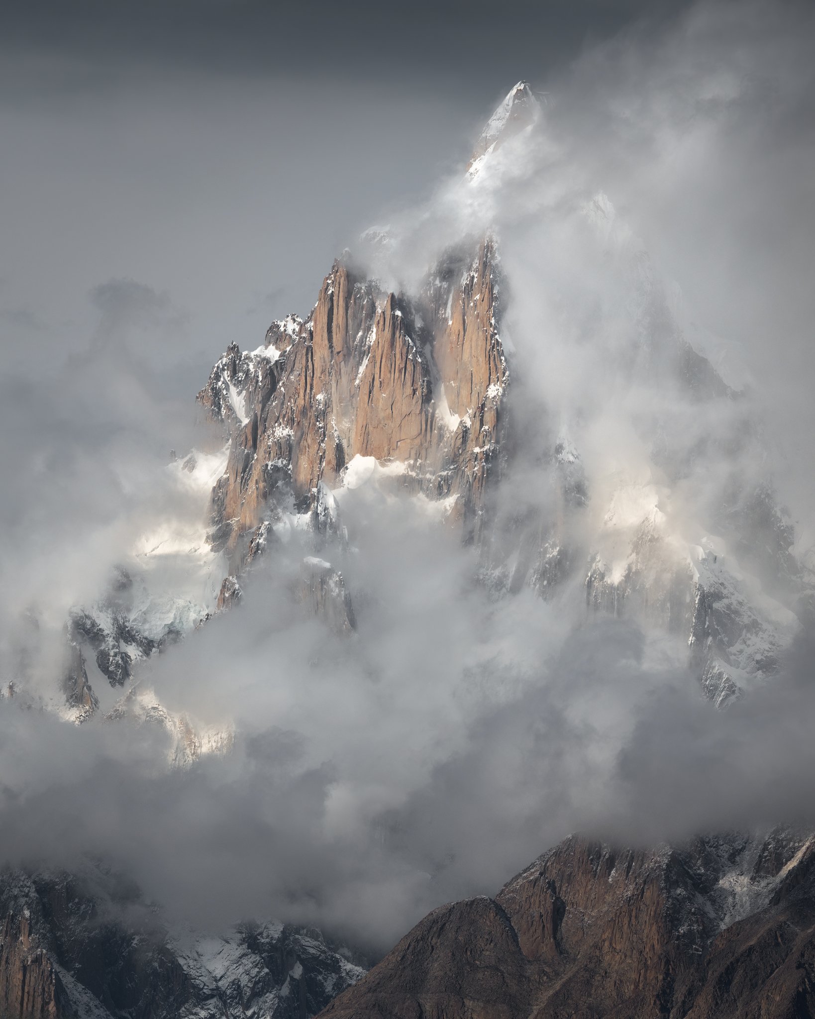 Mount Paiju peaks through the clouds. Taken from the Baltoro Glacier in the Karakoram range, Pakistan